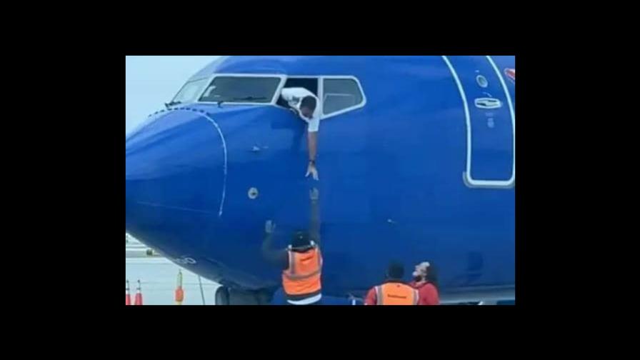 Capitán de avión saca la mano por la ventanilla para recuperar celular de un pasajero