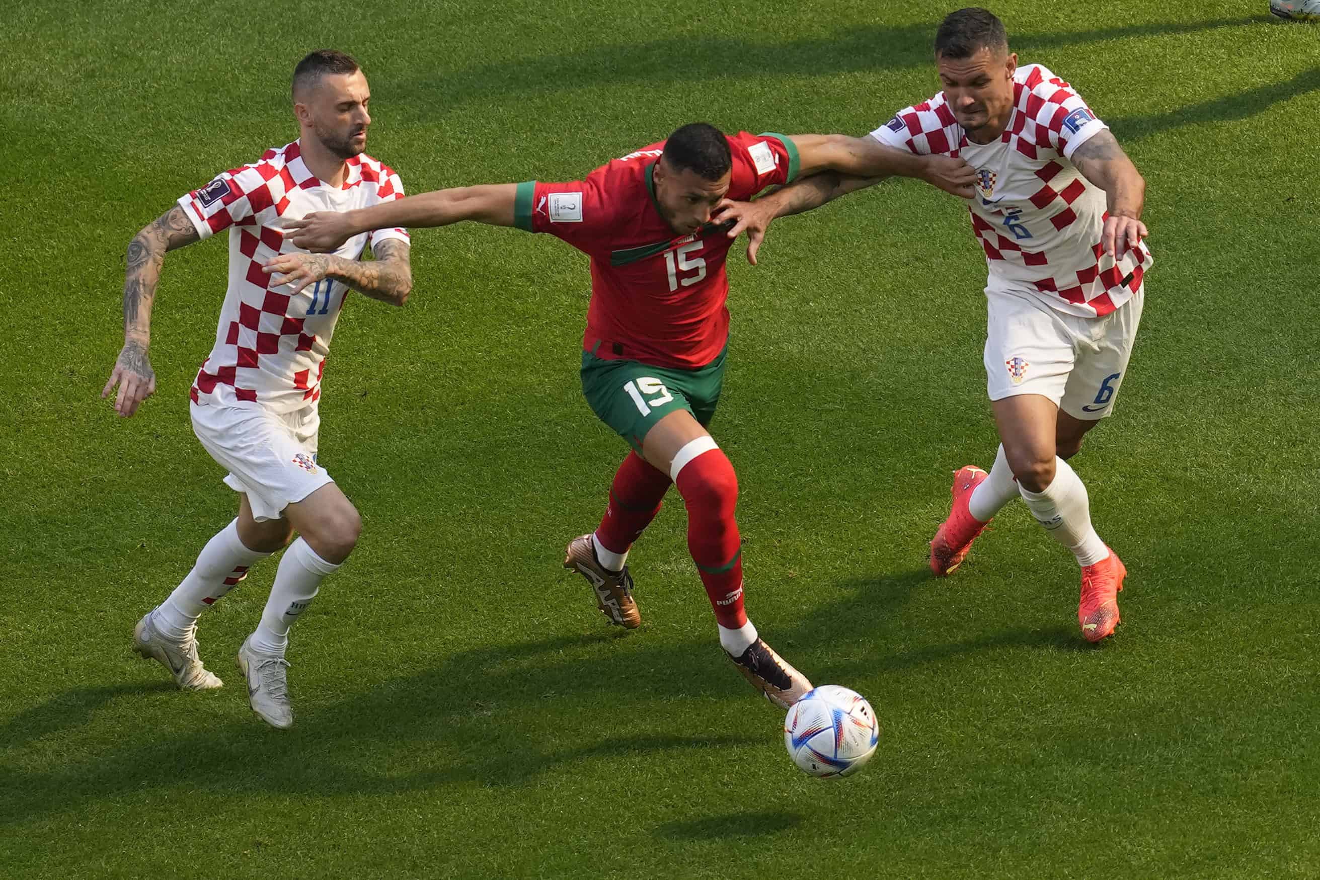 Los croatas Marcelo Brozovic (izquierda) y Dejan Lovren, y el marroquí Selim Amallah intentan llegar a un balón en un partido del Grupo F del Mundial contra Croacia, en el estadio Al Bayt, en Jor, Qatar, el 23 de noviembre de 2022.