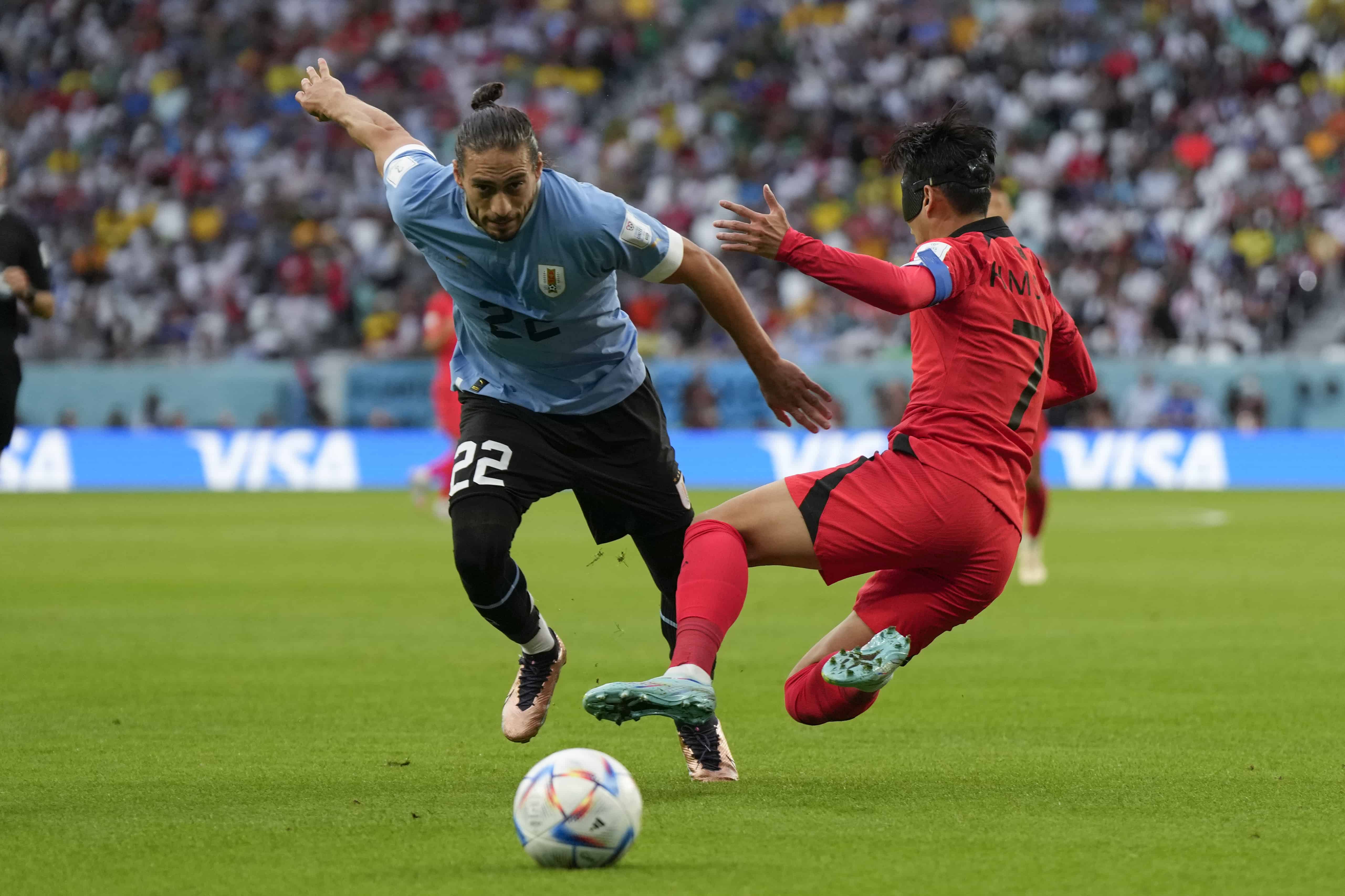 El uruguayo Martín Cáceres (izquierda) y el surcoreano Son Heung-min durante el partido contra Corea del Sur por el Grupo H del Mundial en Al Rayán, Qatar, el jueves 24 de noviembre de 2022. 