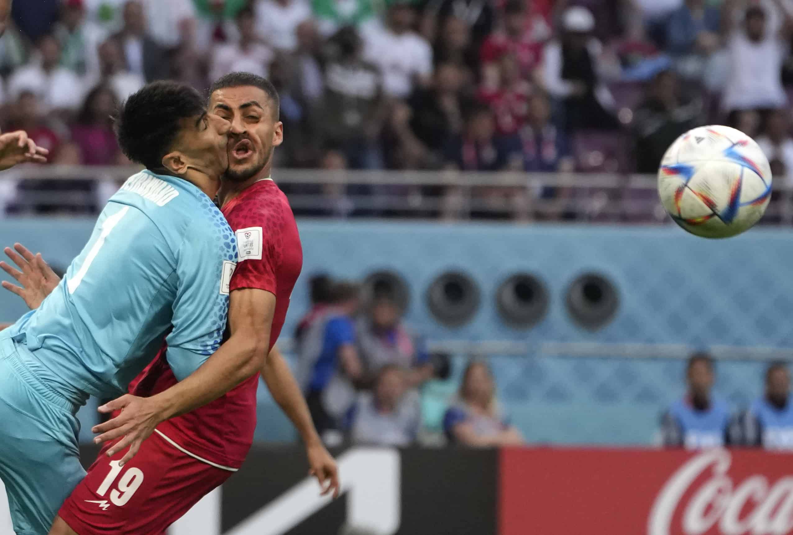 El portero iraní Alireza Beiranvand choca con Majid Hosseini de Irán, a la derecha, durante el partido de fútbol del grupo B de la Copa Mundial entre Inglaterra e Irán en el Estadio Internacional Khalifa en Doha, Qatar, el lunes 21 de noviembre de 2022.