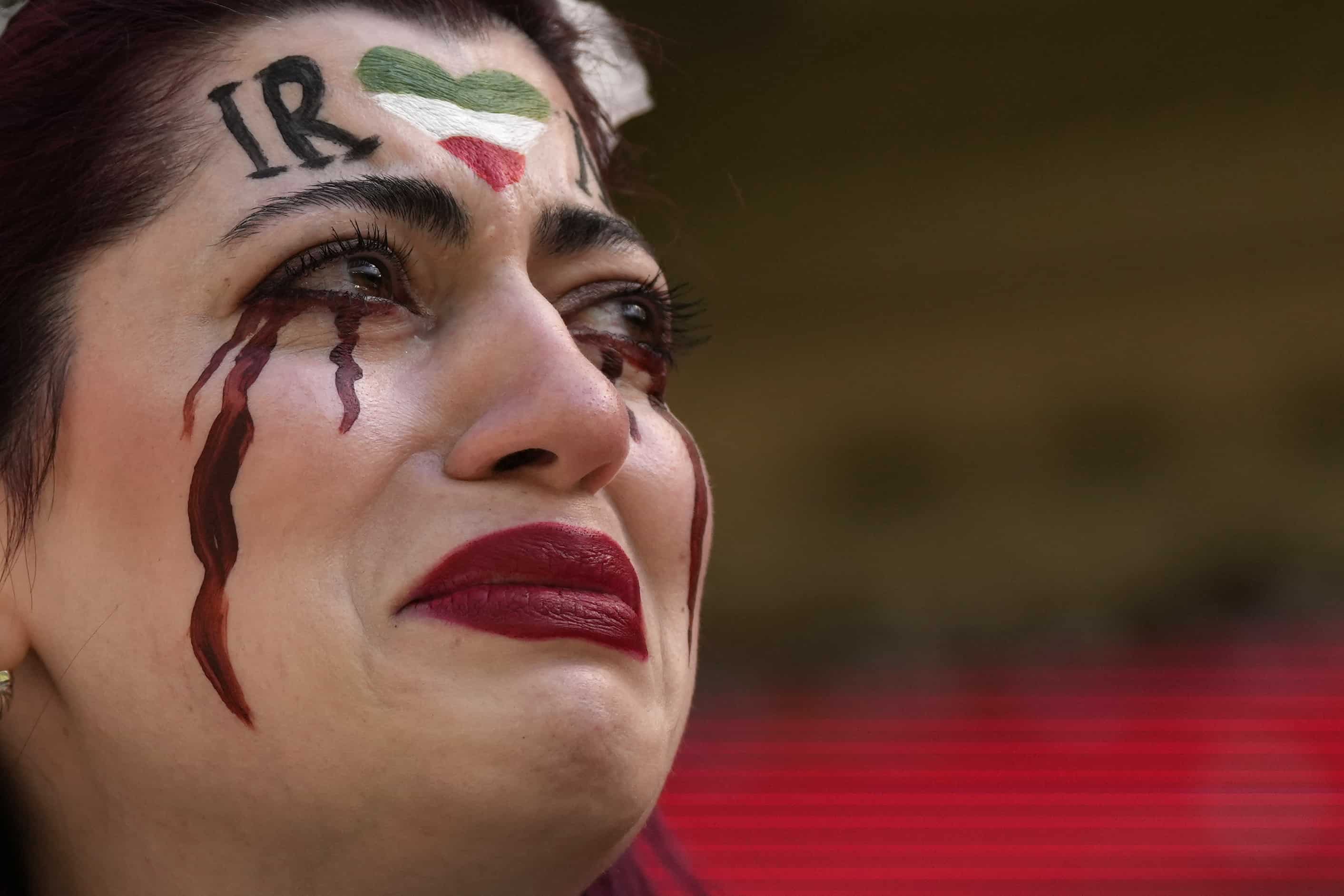 Una mujer iraní, cuyo nombre no se proporciona, rompe a llorar después de que un miembro de la seguridad le quitara la bandera que decía Mujer, vida, libertad antes del inicio del partido de fútbol del grupo B de la Copa Mundial entre Gales e Irán, en el estadio Ahmad Bin Ali en Al Rayyan. , Qatar, viernes 25 de noviembre de 2022.