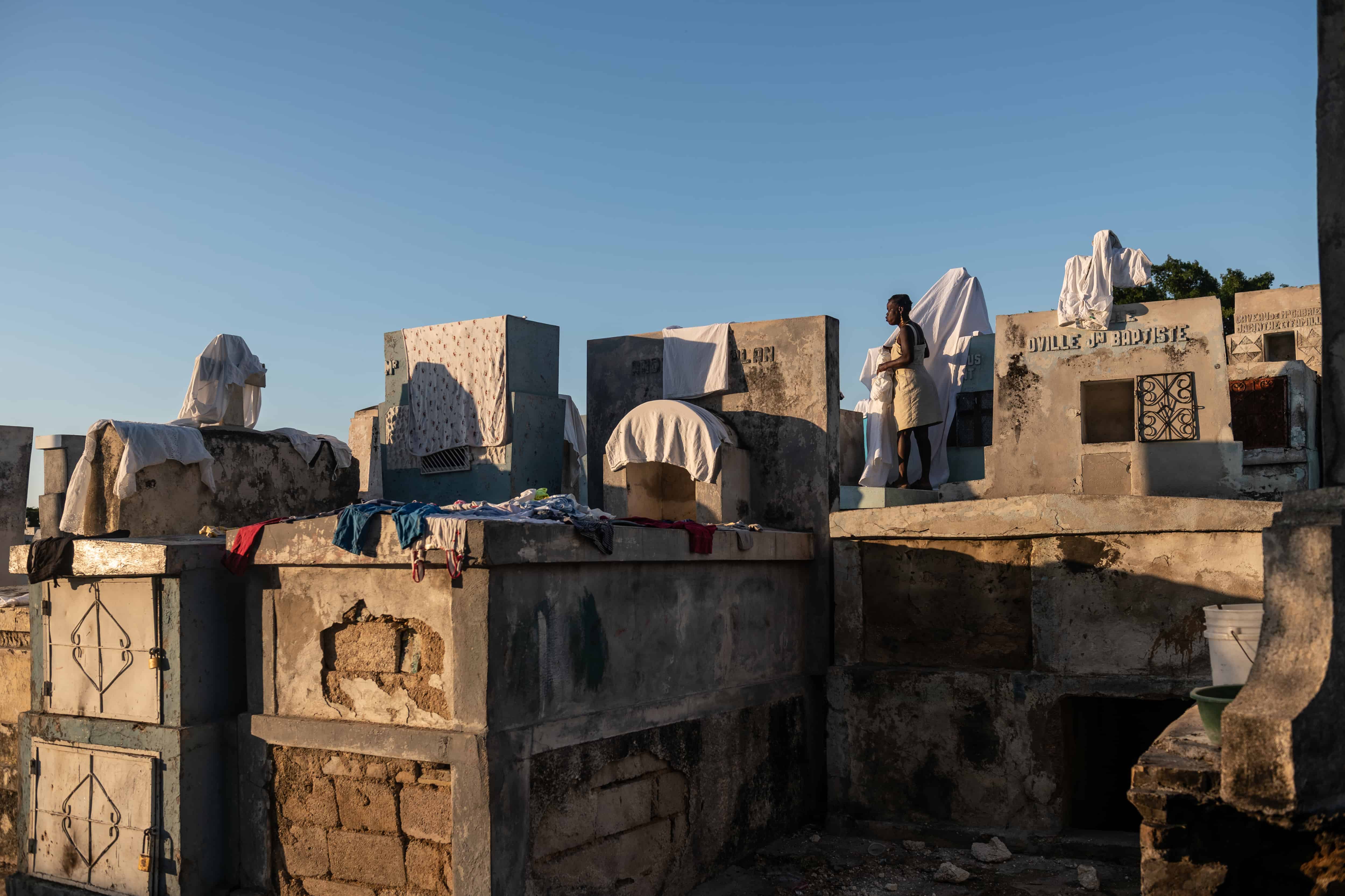 Una mujer que tomó tumbas como su hogar, tiende ropa el 10 de diciembre de 2022, en el Cementerio General de Puerto Príncipe (Haití).