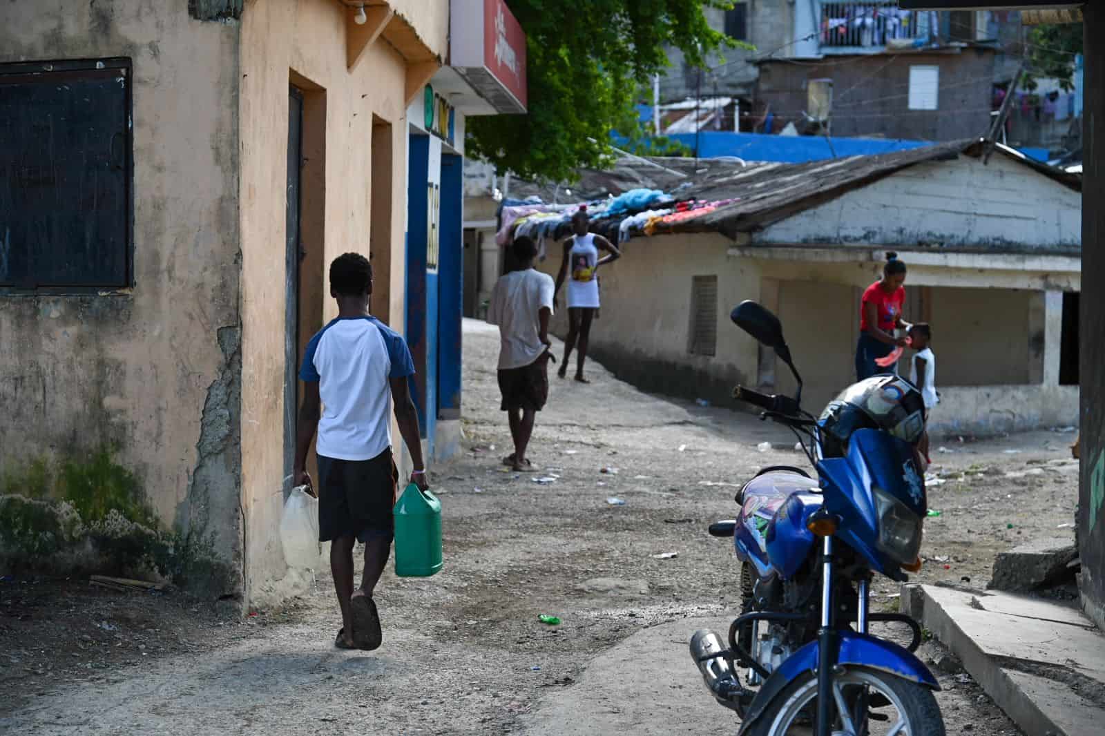 Niño carga con galones de agua en el sector La Zurza.