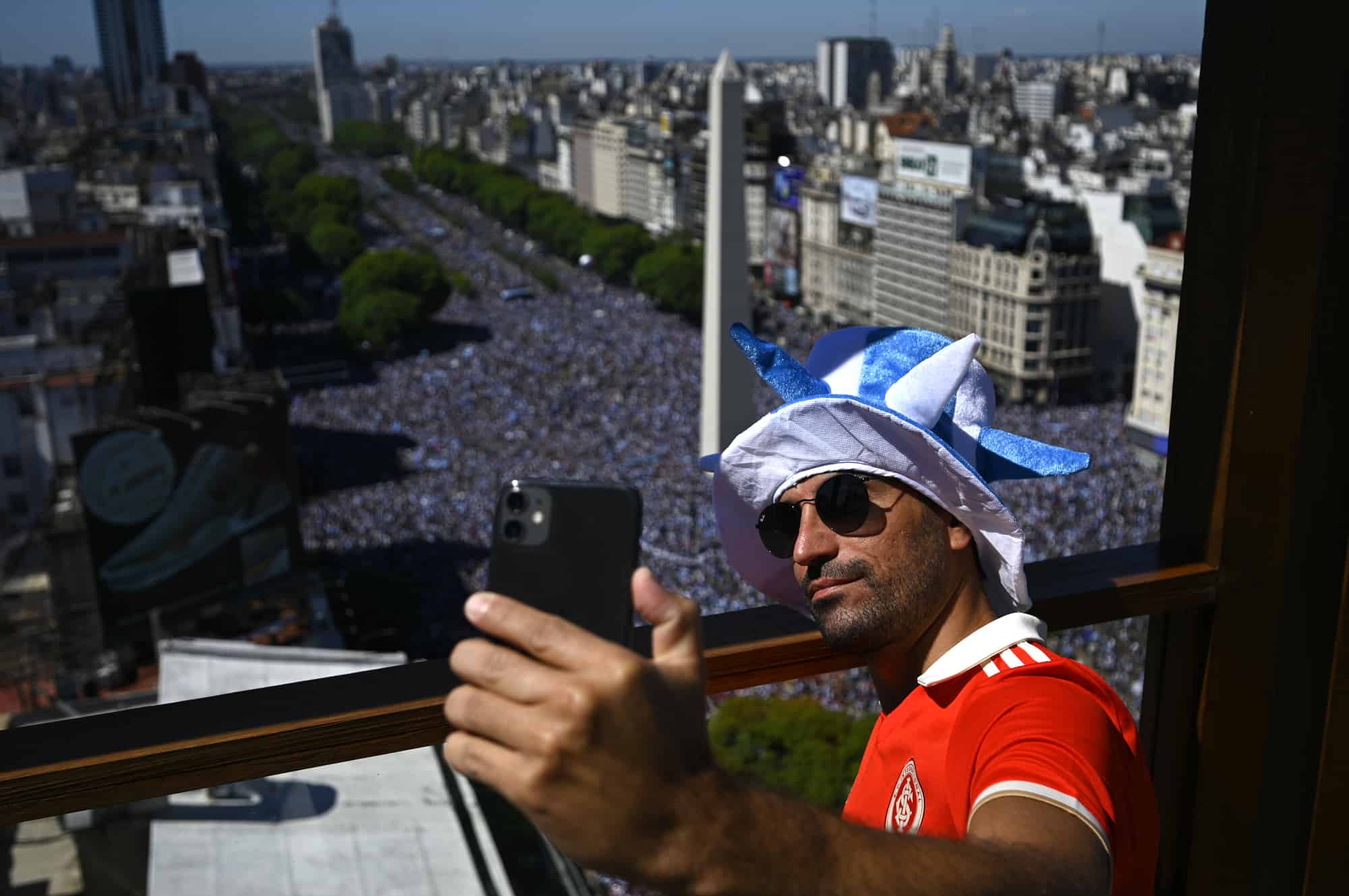 Un hombre se toma una selfie cerca del Obelisco, mientras los hinchas argentinos esperan que pase el autobús con los jugadores de Argentina para celebrar después de ganar la Copa del Mundo de Qatar 2022 en Buenos Aires el 20 de diciembre de 2022.