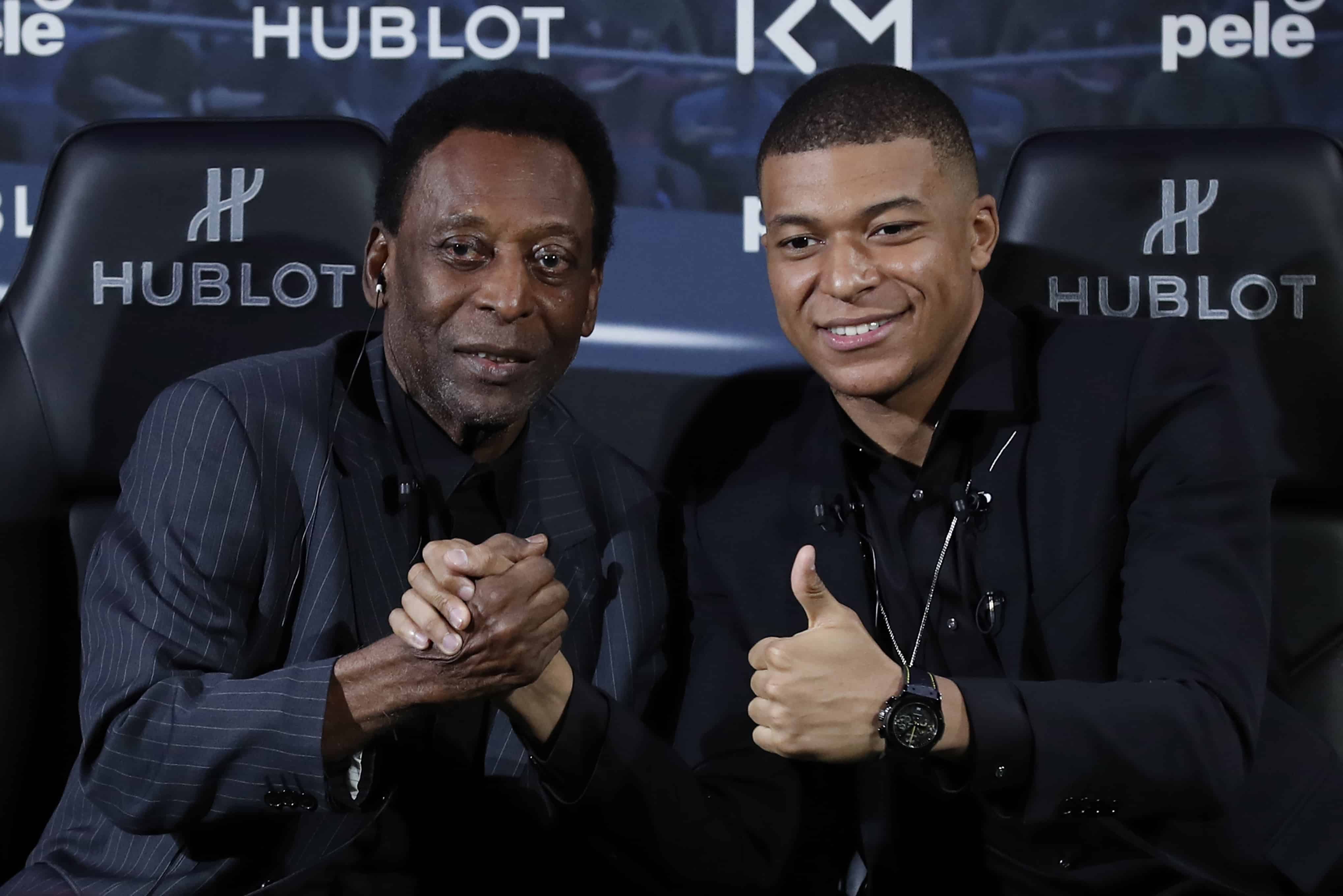 La leyenda del fútbol brasileño Pelé, a la izquierda, y el futbolista francés Kylian Mbappé posan durante una sesión de fotos en París, el martes 2 de abril de 2019.