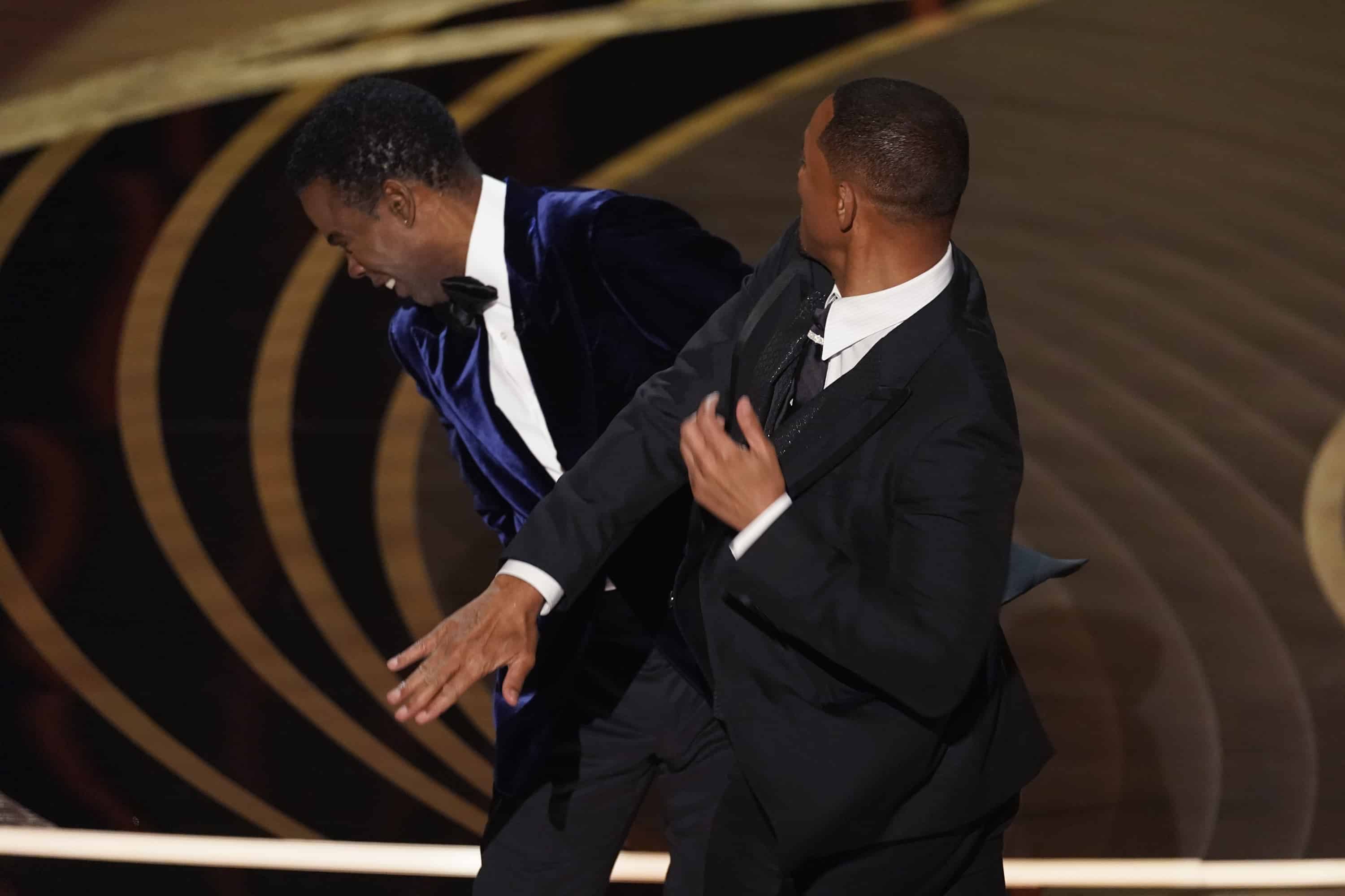 Will Smith, a la derecha, golpea al presentador Chris Rock en el escenario mientras presenta el premio a la mejor película documental en los Oscar el domingo 27 de marzo de 2022 en el Dolby Theatre de Los Ángeles.