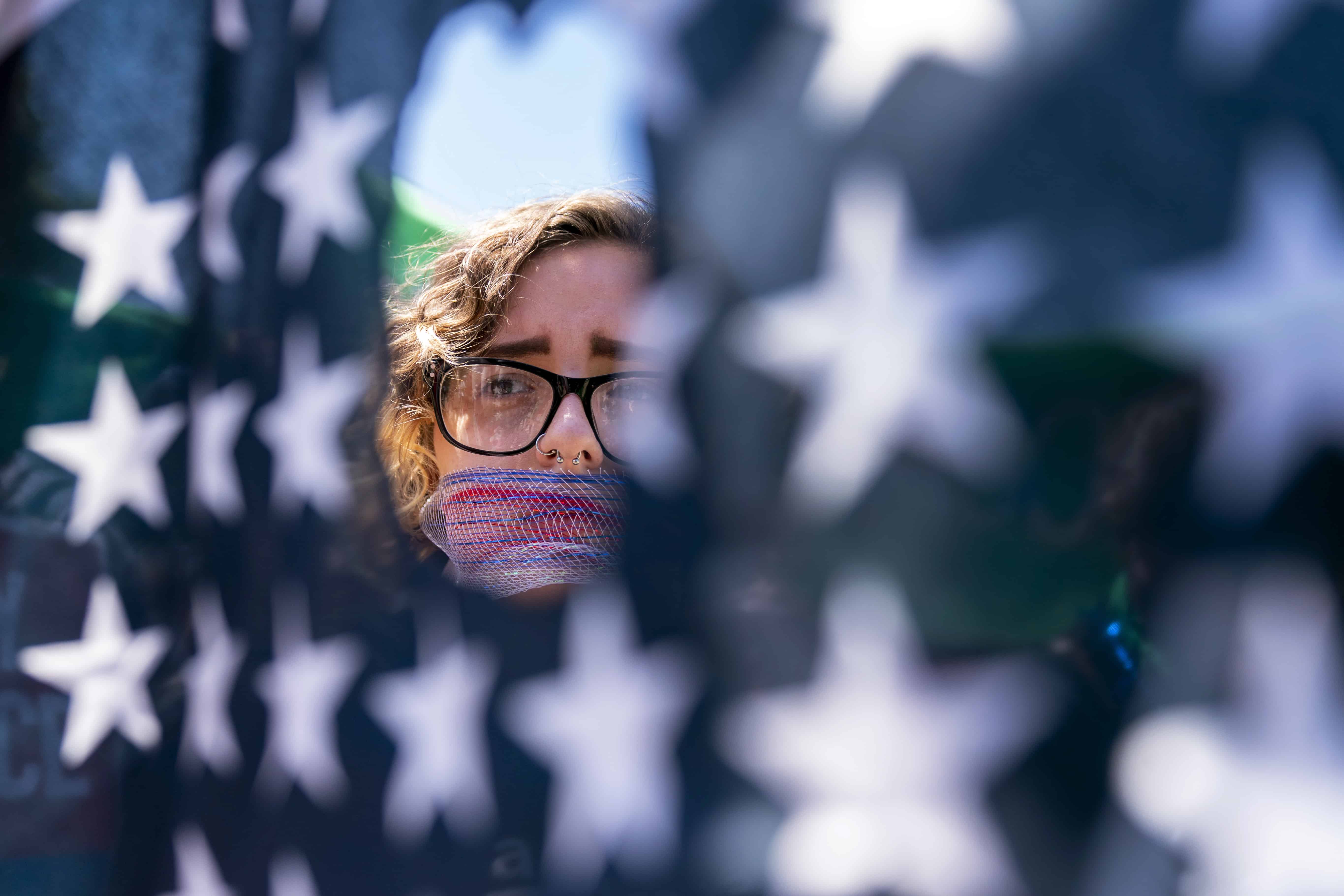 Emma Rousseau, de Oakland, N.J., con la boca vendada con una red roja, blanca y azul, asiste a una manifestación el 4 de julio para protestar por el derecho al aborto, en el Parque Lafayette frente a la Casa Blanca en Washington, el lunes 4 de julio. , 2022. 11