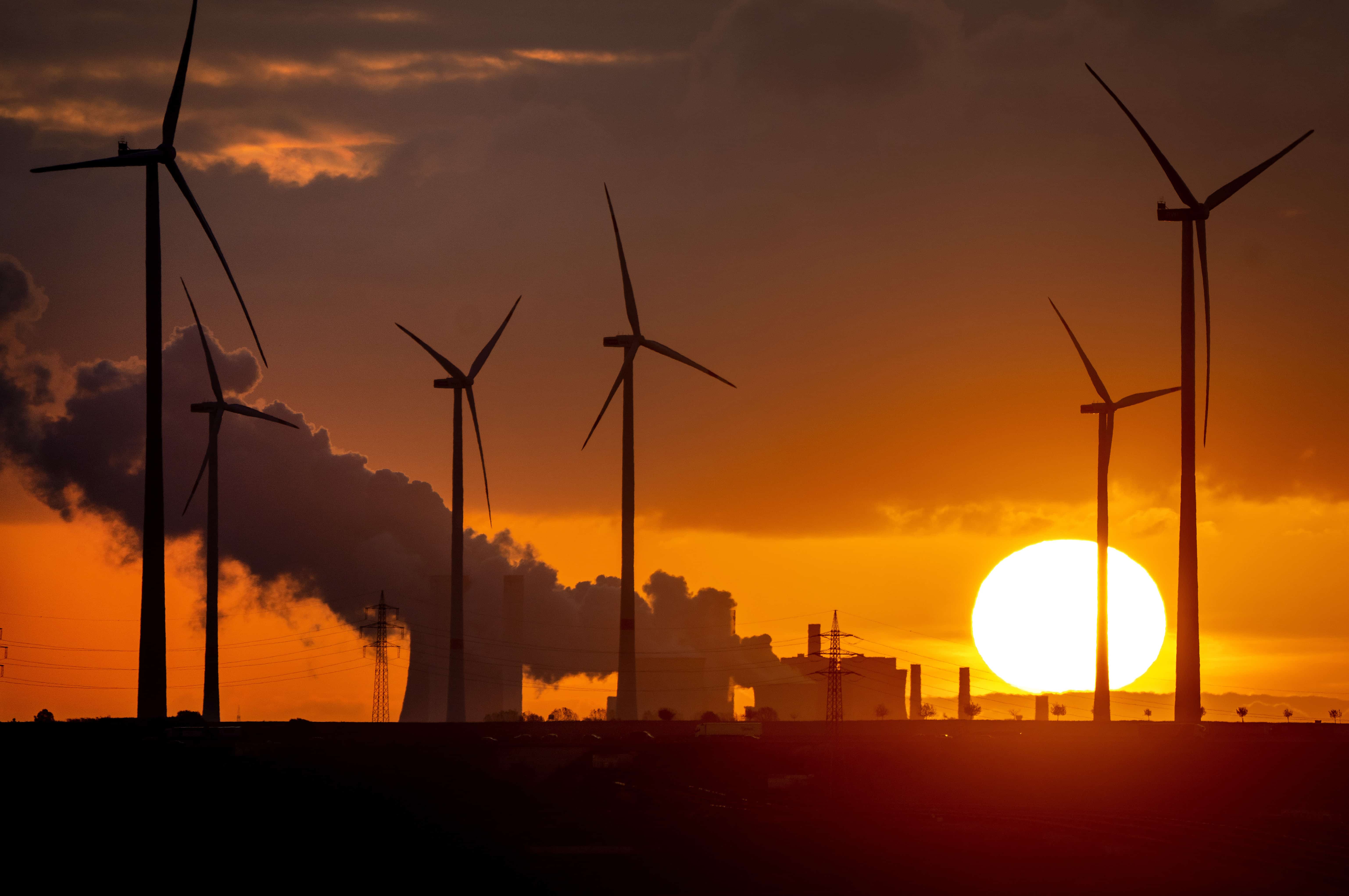 El vapor se eleva desde la planta de energía a carbón cerca de las turbinas eólicas en Niederaussem, Alemania, mientras sale el sol el 2 de noviembre de 2022. Alemania, un firme defensor de la energía limpia, recurrió al carbón y al petróleo para abordar sus necesidades de energía a corto plazo.