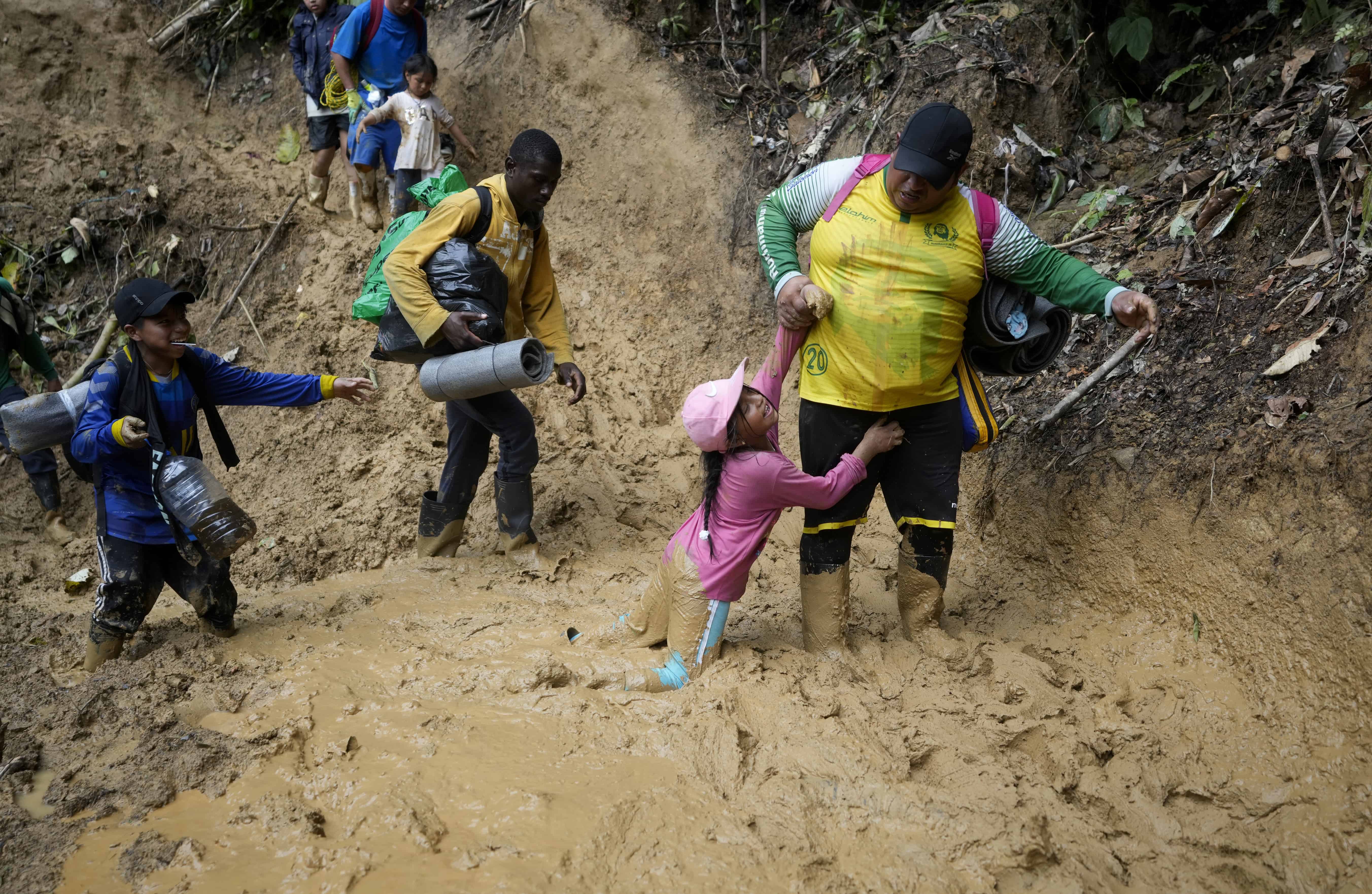 Una mujer tira de una niña para sacarla del lodo mientras migrantes ecuatorianos atraviesan el tapón del Darién desde Colombia hasta Panamá con la esperanza de llegar a Estados Unidos, el sábado 15 de octubre de 2022.