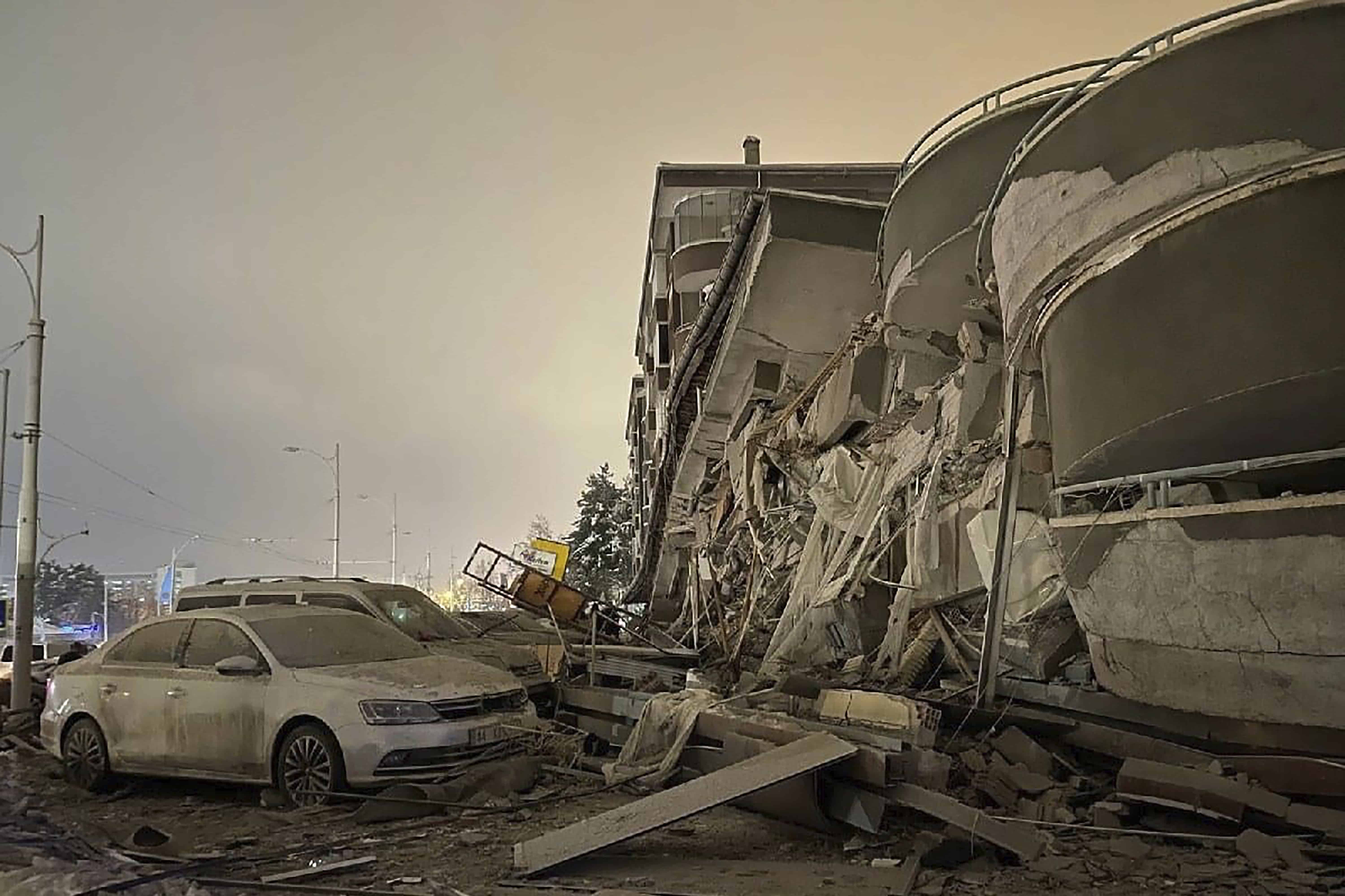 Los vehículos dañados se encuentran estacionados frente a un edificio derrumbado luego de un terremoto en Diyarbakir, sureste de Turquía, la madrugada del lunes 6 de febrero de 2023. Un poderoso terremoto derribó varios edificios en el sureste de Turquía y Siria y se temen muchas víctimas.