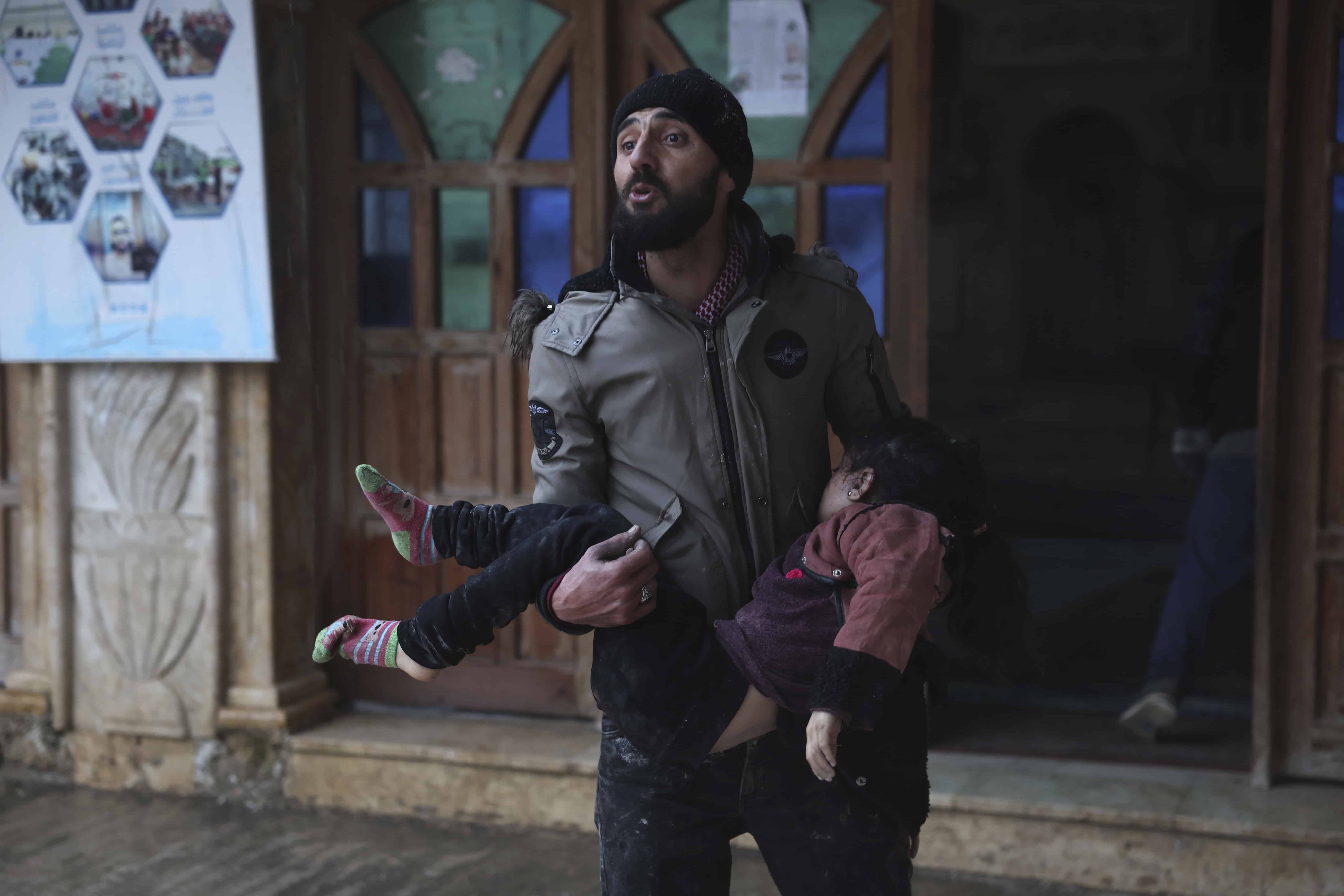 Un hombre sirio lleva a una niña muerta en la ciudad de Azmarin, en la provincia de Idlib, en el norte de Siria, el lunes 6 de febrero de 2023. Un poderoso terremoto golpeó el sureste de Turquía y Siria el lunes por la mañana, derribando edificios y enviando a los residentes en pánico a salir en un frío invierno. noche.