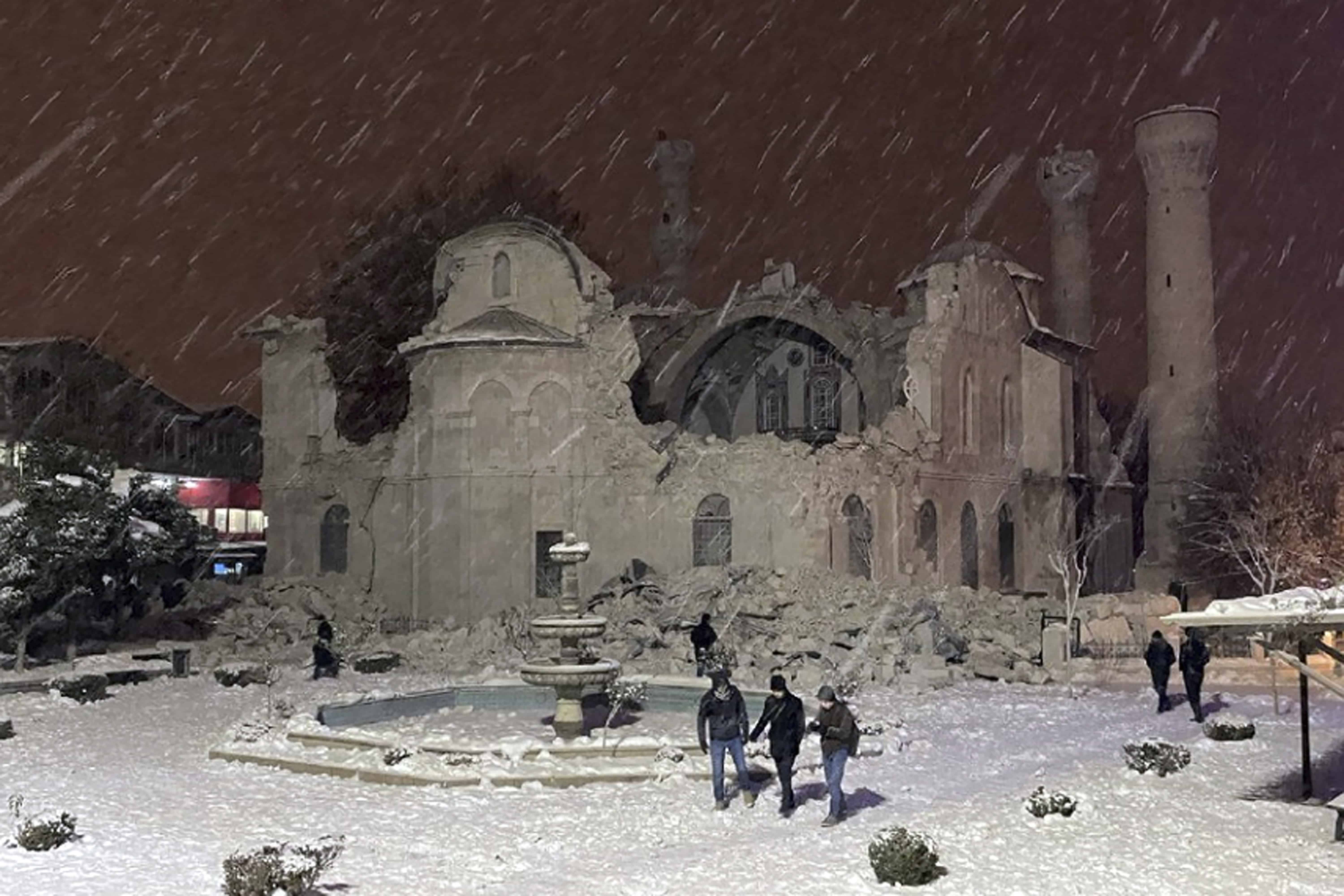 La gente camina junto a una mezquita destruida por un terremoto en Malatya, Turquía, el lunes 6 de febrero de 2023. Un poderoso sismo derribó varios edificios en el sureste de Turquía y Siria y se temen muchas víctimas.