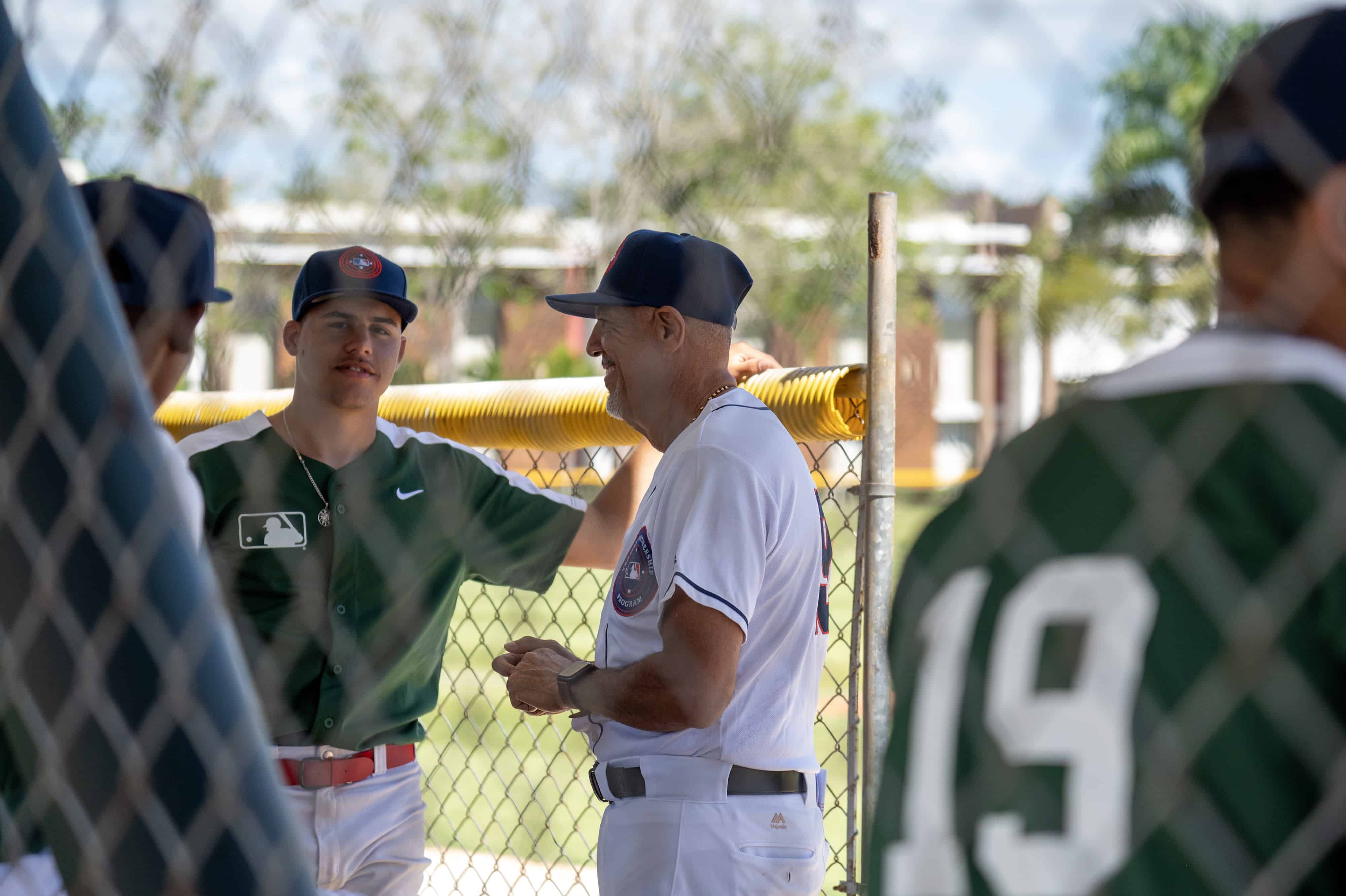 El expelotero Luis Sojo, al centro, conversa con jóvenes en la academia de los Cubs.