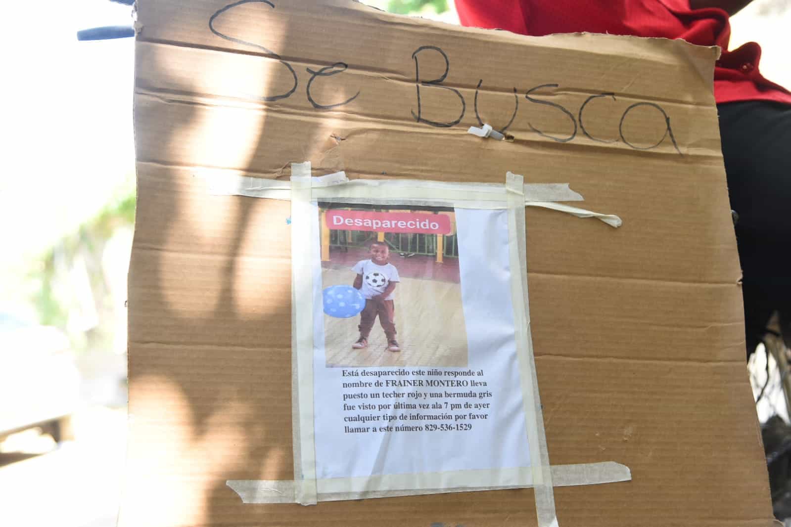 Un pedazo de cartón con una imagen del niño desaparecido e información de la familia.