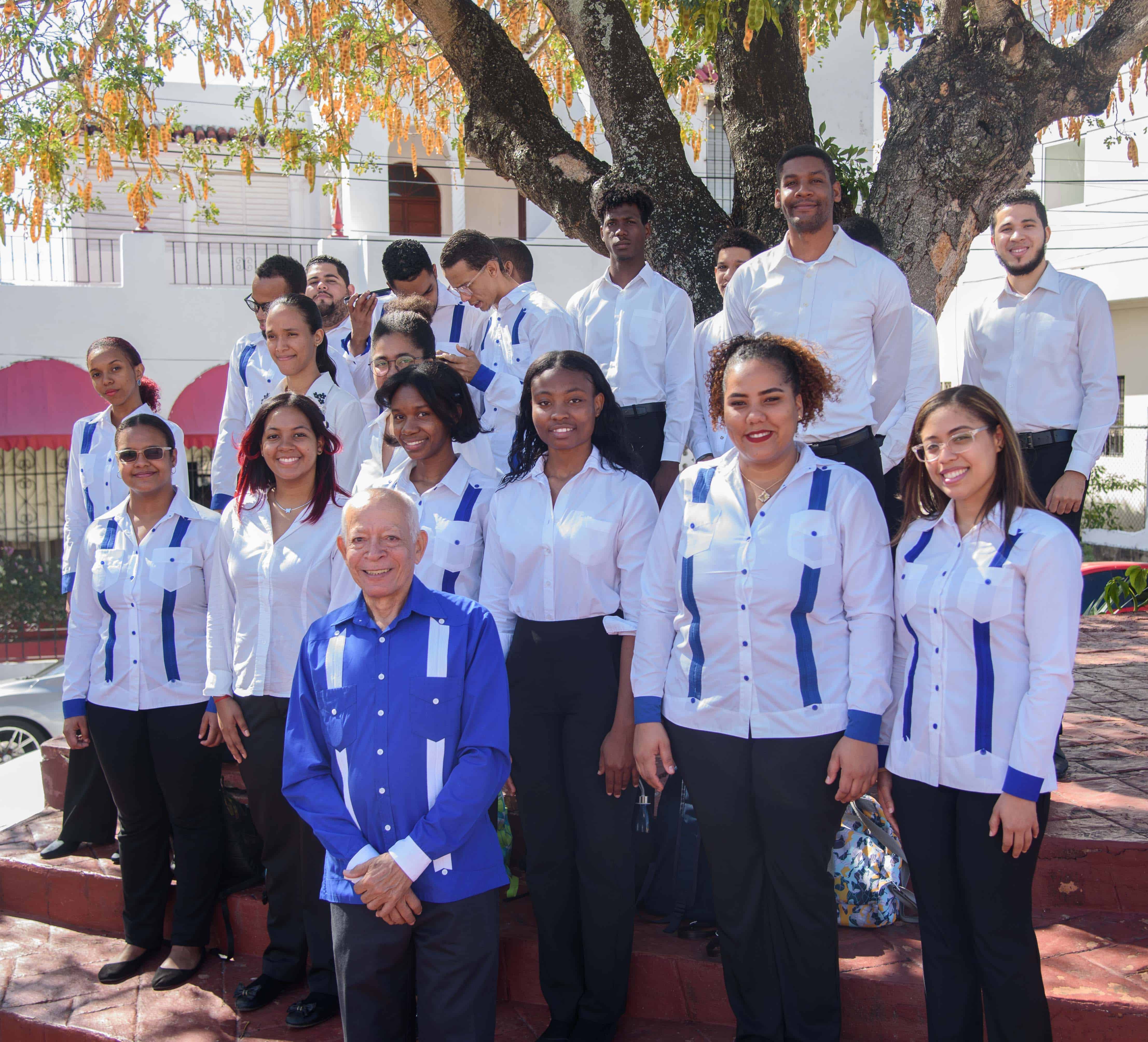 Integrantes del coro de la UASD junto al director.