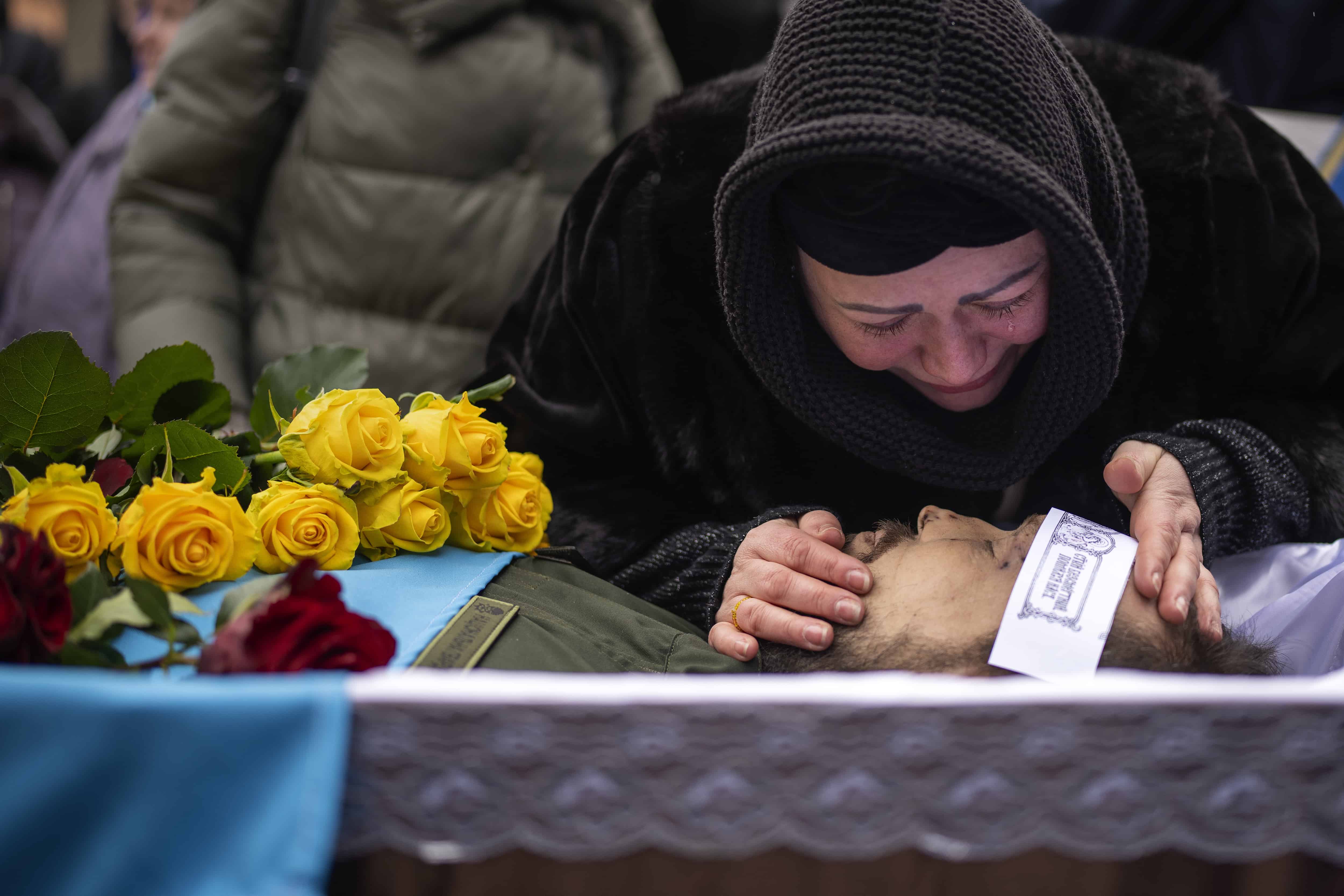 Roza llora sobre el cuerpo de su esposo Oleksandr Maksymenko, de 38 años, durante su funeral en su pueblo natal Kniazhychi, al este de Kyiv, Ucrania, el lunes 13 de febrero de 2023. Oleksandr, un civil que fue voluntario en las fuerzas armadas de Ucrania, murió en los combates en el área de Bakhmut.