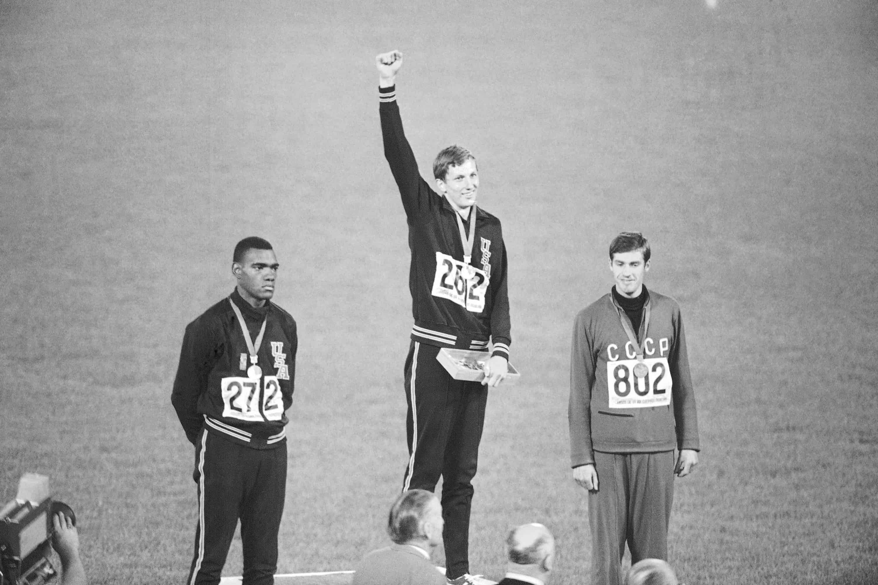 El ganador de la medalla de oro, el estadounidense Dick Fosbury, levanta el brazo en el podio de los vencedores del estadio olimpico, el 20 de octubre de 1968, en la Ciudad de Mexico. A la izquierda esta el medallista de plata Ed Caruthers de los EE. UU. y a la derecha esta el medallista de bronce Valentin Gavrilov de Rusia. Fosbury, el saltador larguirucho que renovo por completo la disciplina tecnica del salto de altura y gano una medalla de oro olimpica con su Fosbury Flop, murio despues de una recurrencia de linfoma. Fosbury murio el domingo 12 de marzo de 2023, segun su publicista, Ray Schulte. Tenia 76 anos.