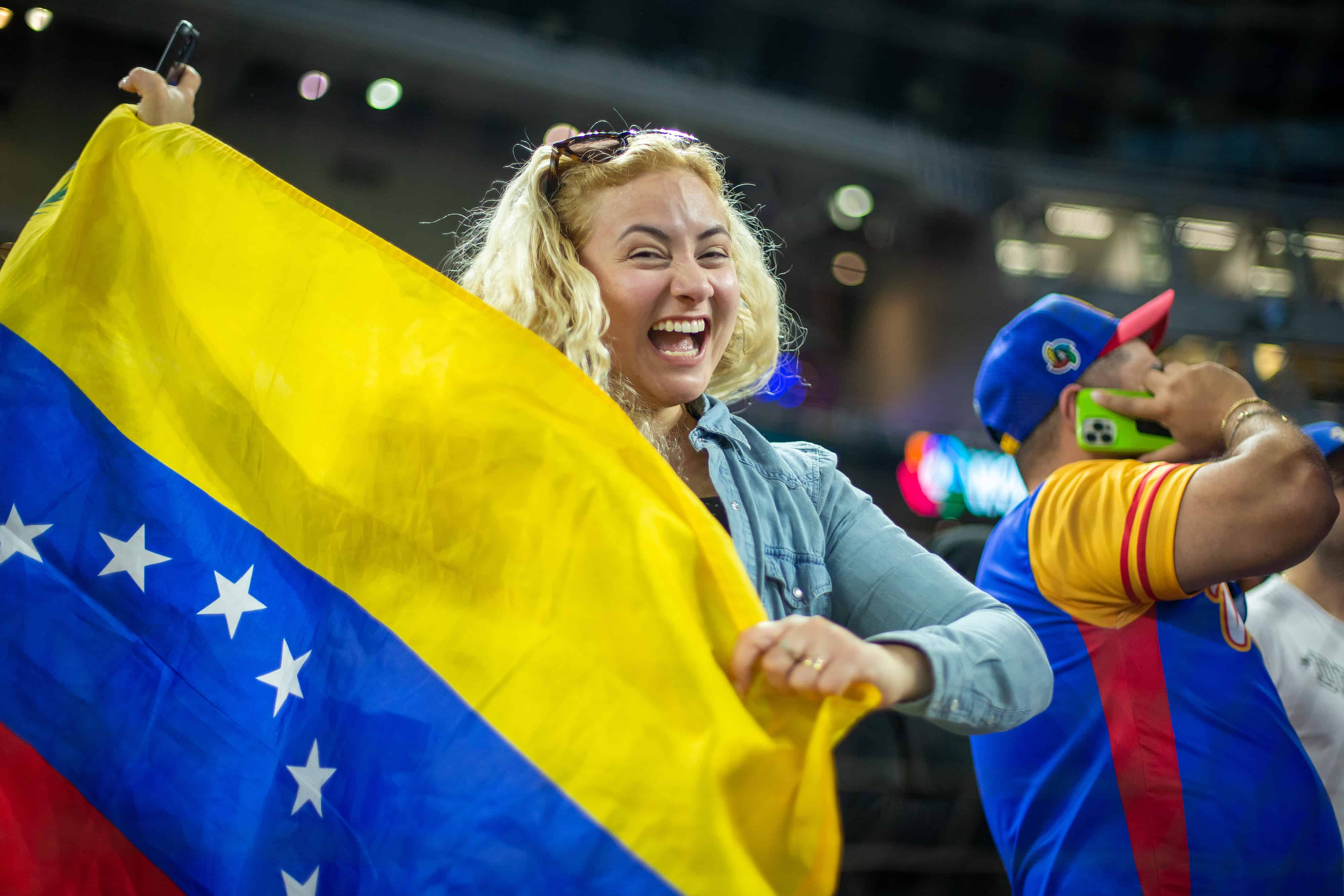 Feliz y orgullosa, una fanática venezolana muestra la bandera tricolor en el LoanDepot Park de Miami.