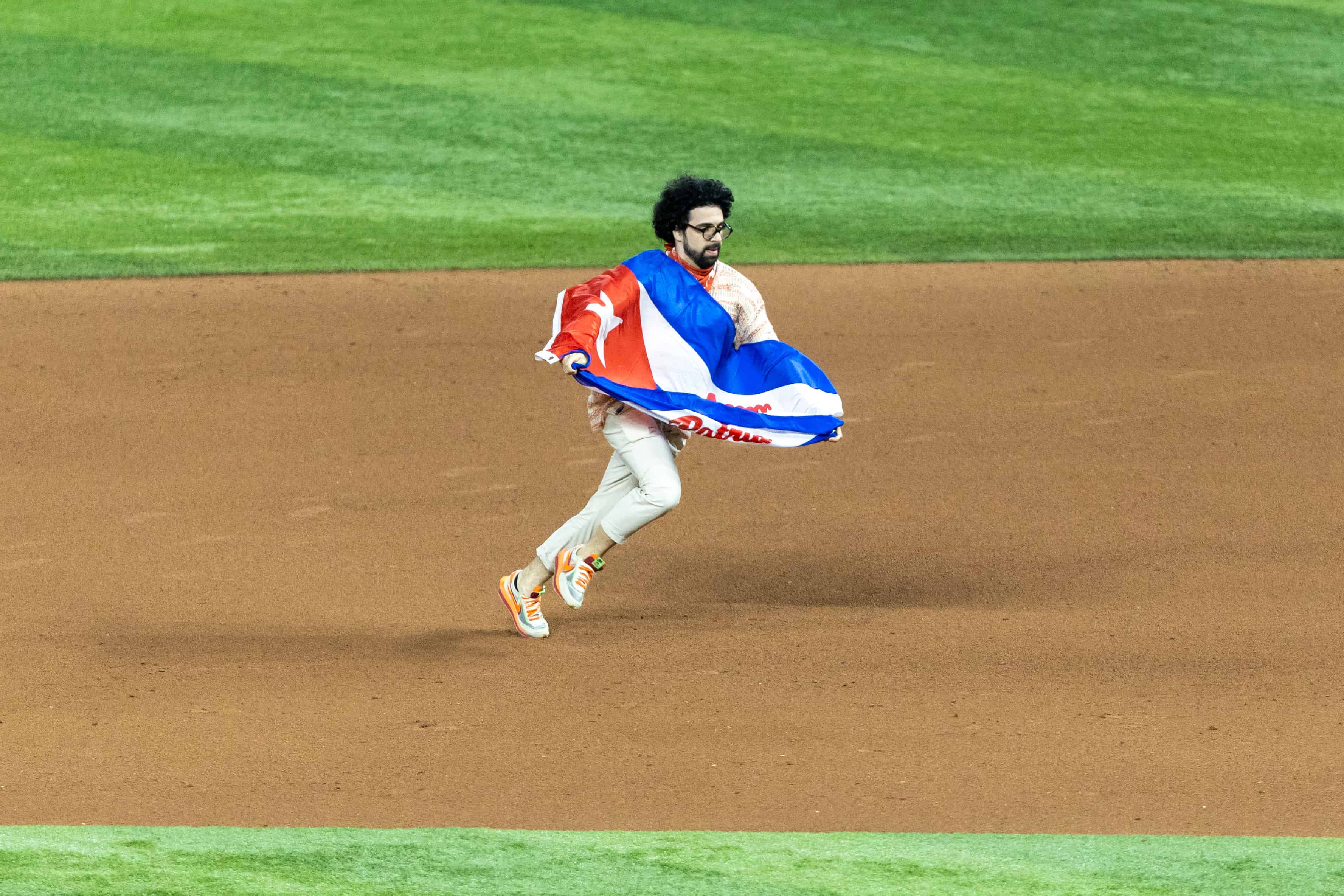 Portando una una bandera cubana con el lema Patria y vida , un espontáneo buró la seguridad del Loan Depot Park.