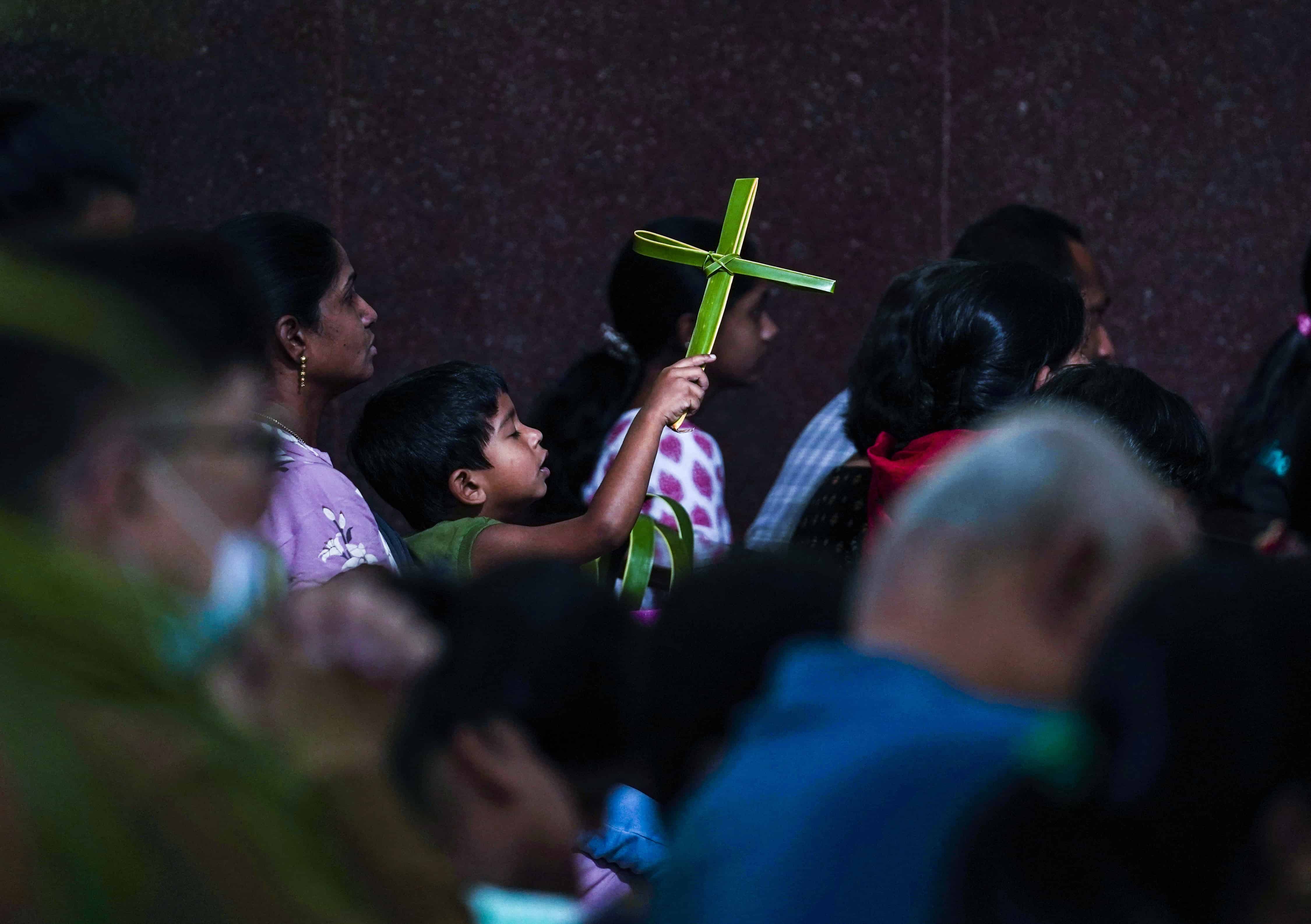 Un niño católico sostiene una cruz hecha de hojas de palma bendecidas durante una misa del Domingo de Ramos en la Catedral de San José en Hyderabad, India, el domingo 2 de abril de 2023. El Domingo de Ramos marca el sexto y último domingo del mes sagrado cristiano de Cuaresma y el comienzo de Semana Santa.