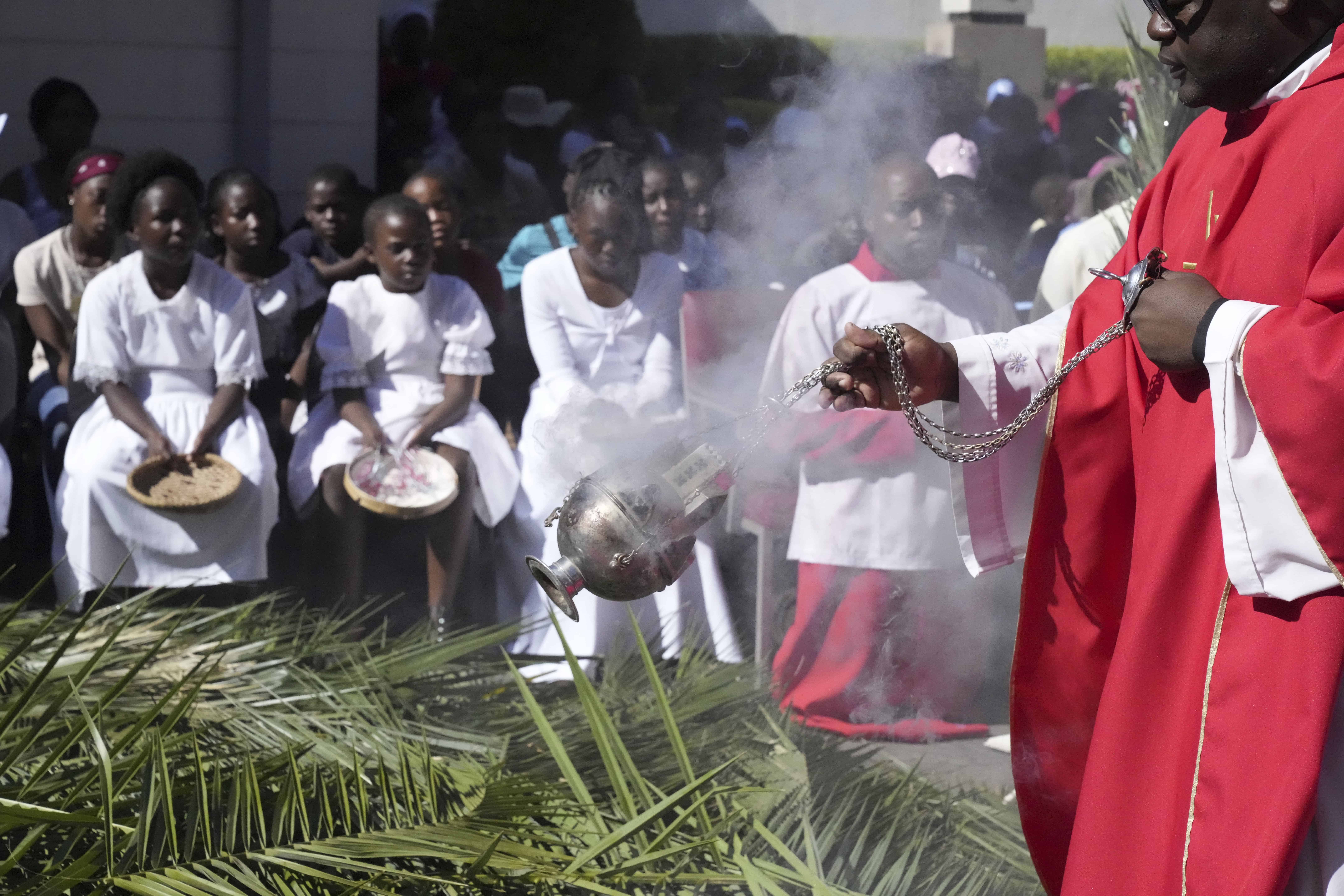 Un sacerdote esparce incienso durante las actividades para conmemorar el Domingo de Ramos en la Iglesia Católica Romana en Harare, el domingo 2 de abril de 2023.