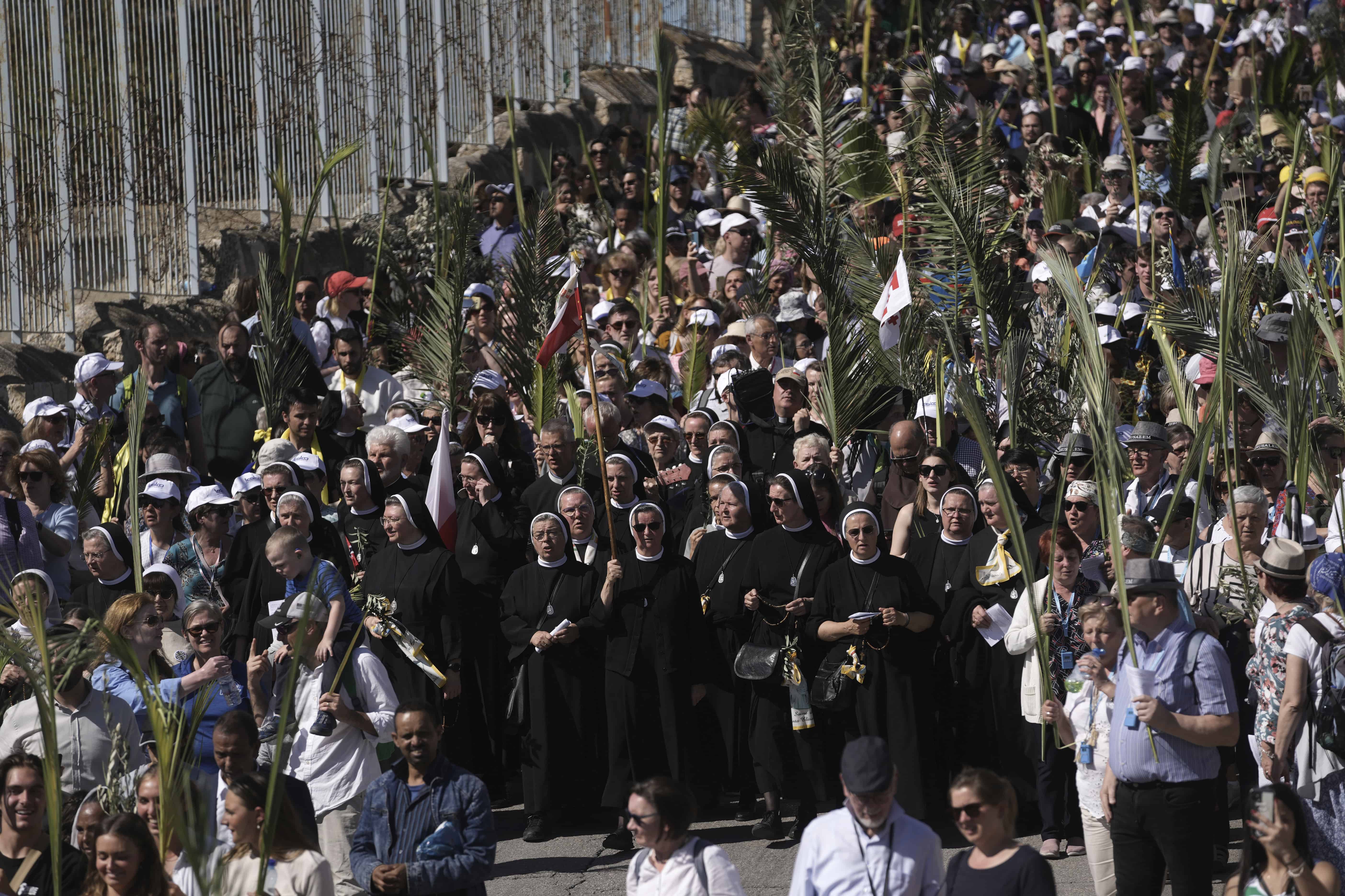 Los cristianos caminan en la procesión del Domingo de Ramos en el Monte de los Olivos en el este de Jerusalén, el domingo 2 de abril de 2023. La procesión observa la entrada de Jesús a Jerusalén en el tiempo previo a su crucifixión, que los cristianos celebran el Viernes Santo.