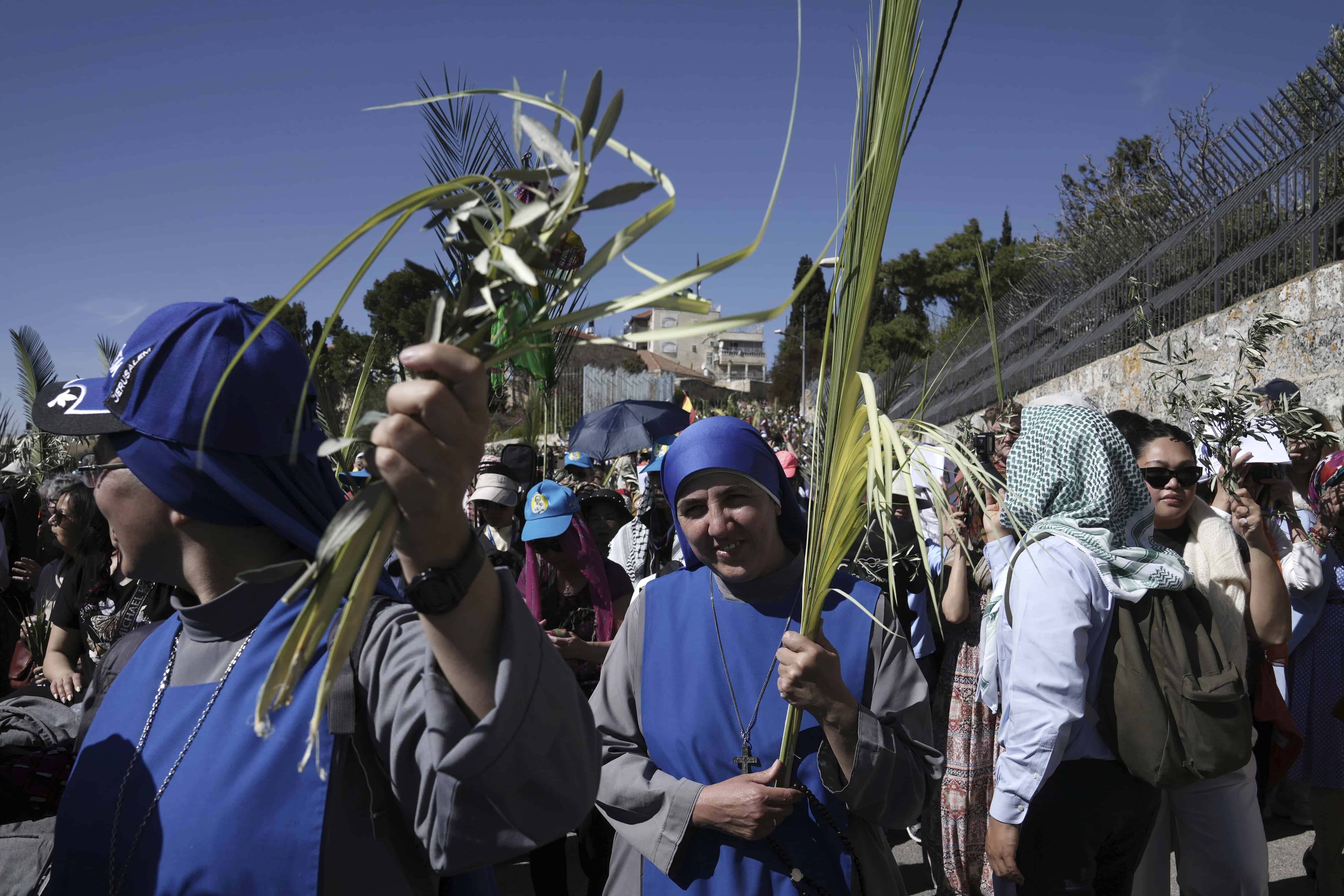 Las monjas llevan hojas de palma mientras los cristianos caminan en la procesión del Domingo de Ramos en el Monte de los Olivos en el este de Jerusalén, el domingo 2 de abril de 2023. La procesión observa la entrada de Jesús a Jerusalén en el tiempo previo a su crucifixión, que los cristianos marcan en Buena Viernes.