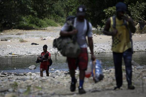  Personas migrantes de Haití cruzan el río Tuquesa tras ser trasladados en canoa desde la Quebrada León hasta a la comunidad de Bajo Chiquito