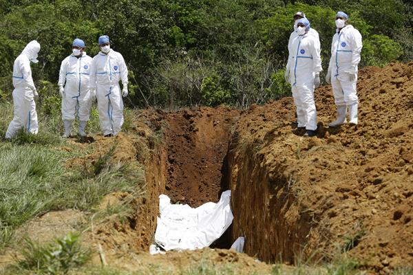 Trabajadores forenses entierran, el 17 de marzo de 2023, los cuerpos de migrantes fallecidos durante un accidente en autobús el pasado mes de febrero, en David (Panamá)