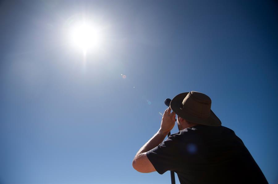 Una persona mira a través de una lente al sol antes de un eclipse solar total en un sitio de observación a 24 km de Exmouth, Australia Occidental, Australia, el 20 de abril de 2023. El eclipse solar total ocurrirá en una península remota en la costa de Australia Occidental.