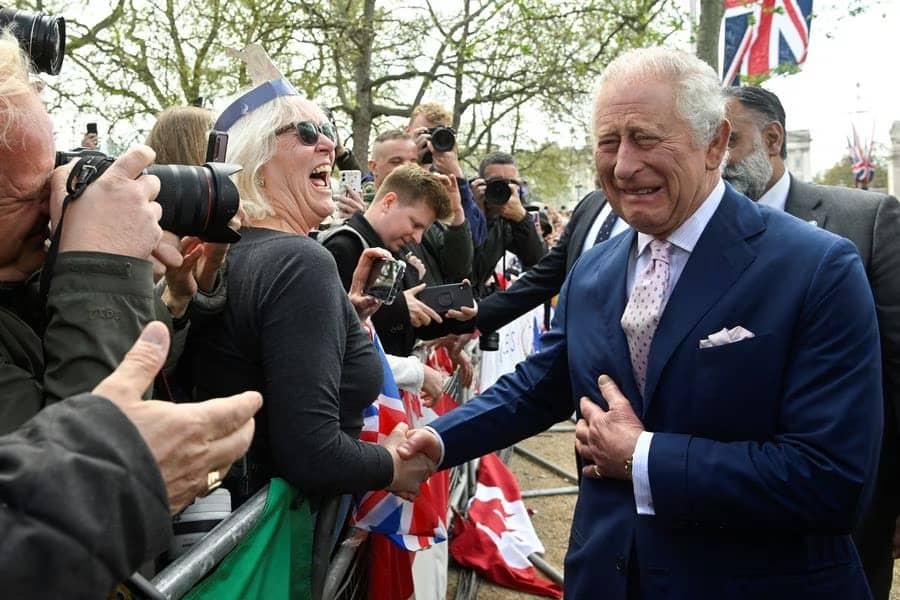 El rey Carlos III reacciona cuando se encuentra con simpatizantes durante un paseo por el centro comercial en las afueras del Palacio de Buckingham