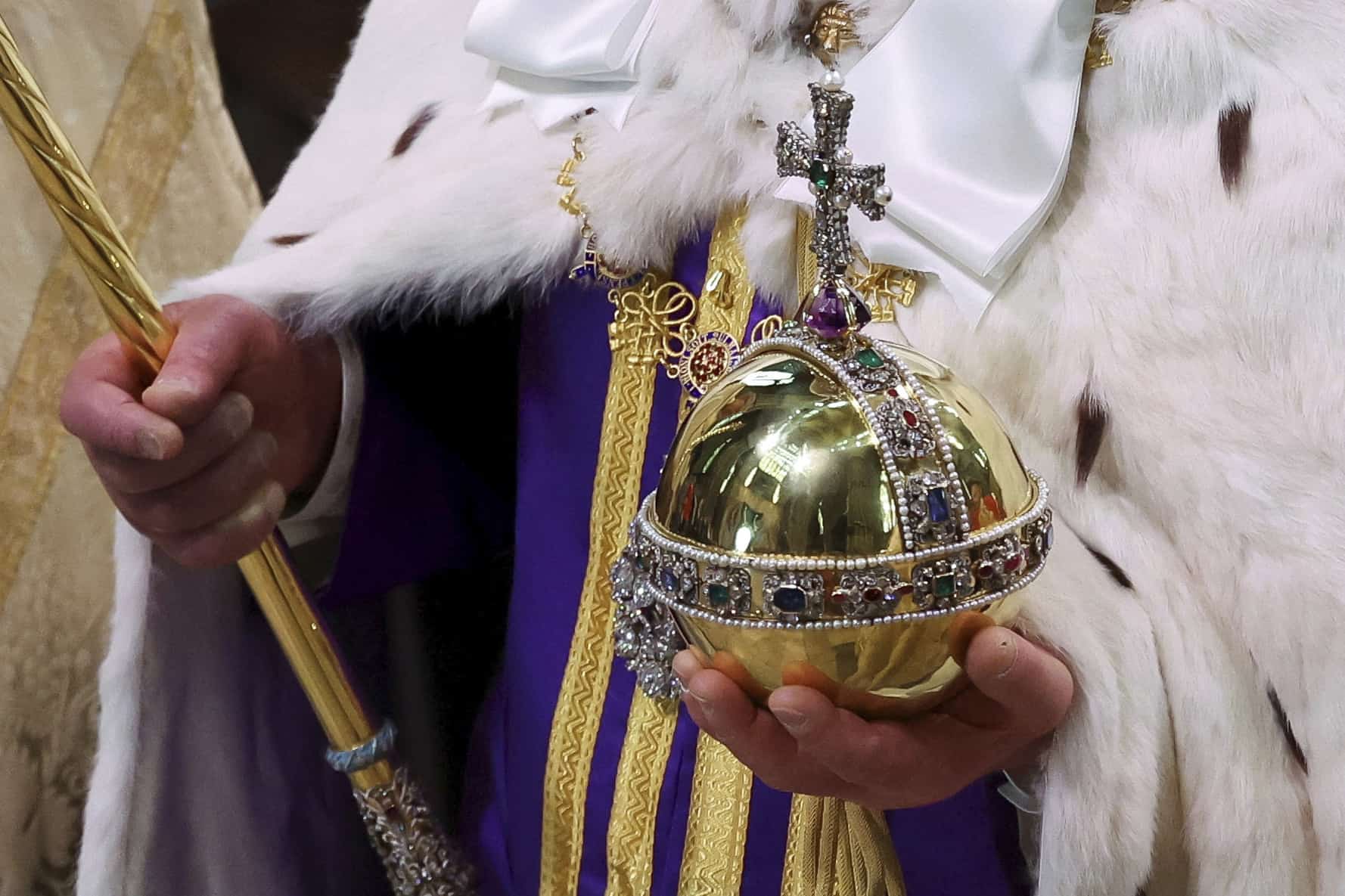 El rey Carlos III de Gran Bretaña sostiene el Orbe y el Cetro del Soberano cuando se va después de su ceremonia de coronación, en la Abadía de Westminster, en Londres, el sábado 6 de mayo de 2023.
