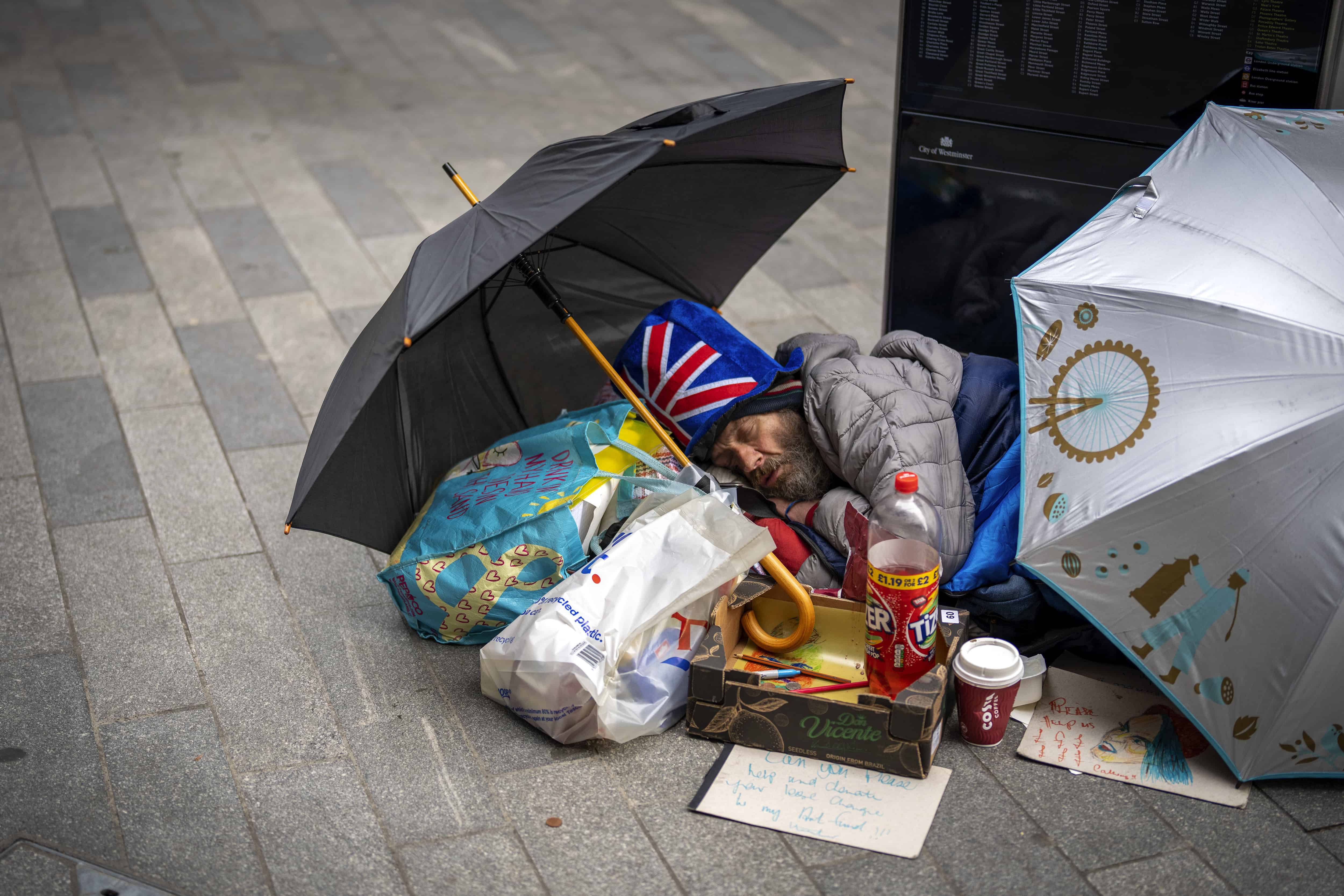 Un hombre duerme en el suelo antes de la ceremonia de coronación del rey Carlos III de Gran Bretaña en Londres, el sábado 6 de mayo de 2023.
