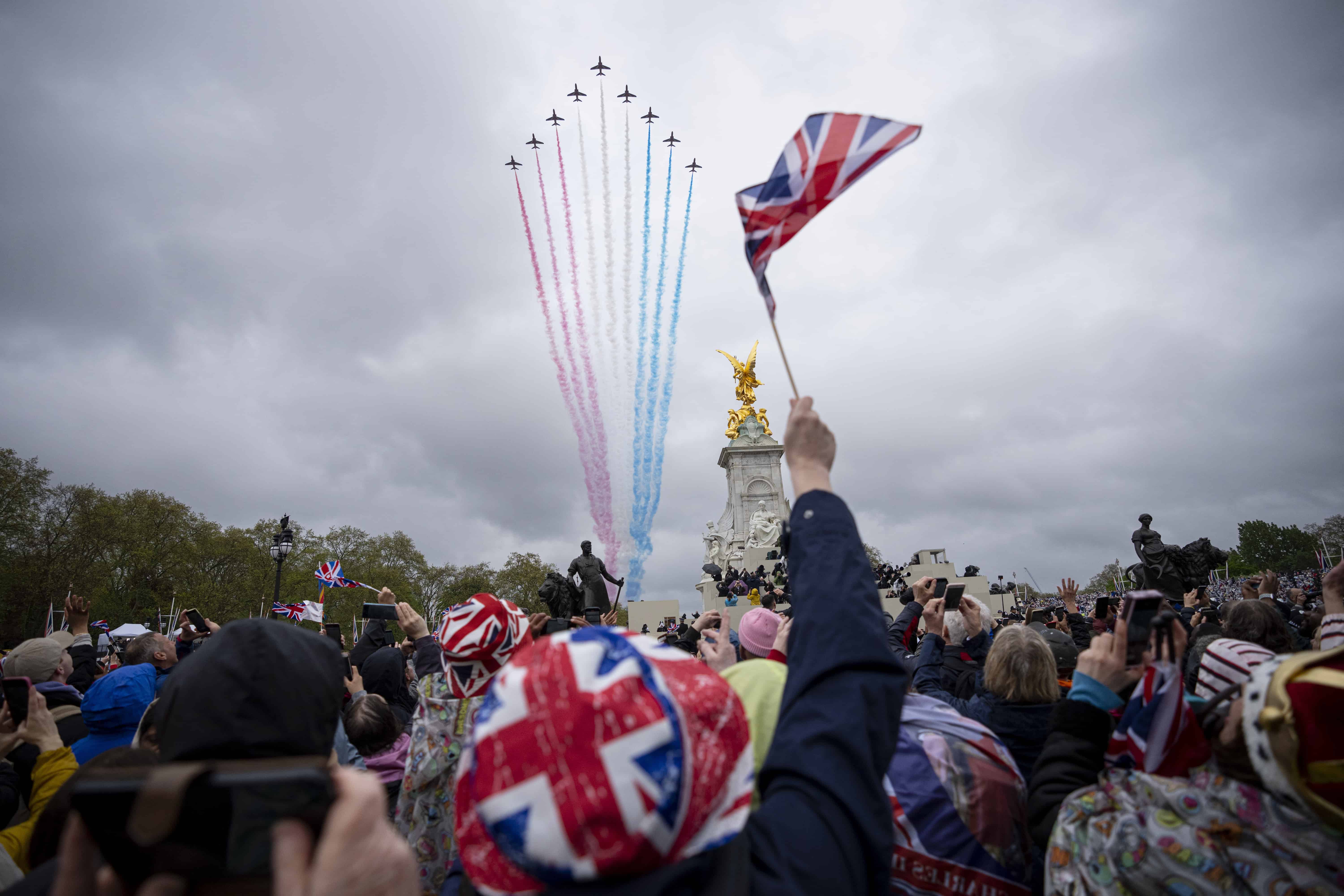 La gente ve pasar el vuelo mientras el rey Carlos III y la reina Camila de Gran Bretaña saludan a la multitud desde el balcón del Palacio de Buckingham después de la ceremonia de coronación en Londres, el sábado 6 de mayo de 2023.