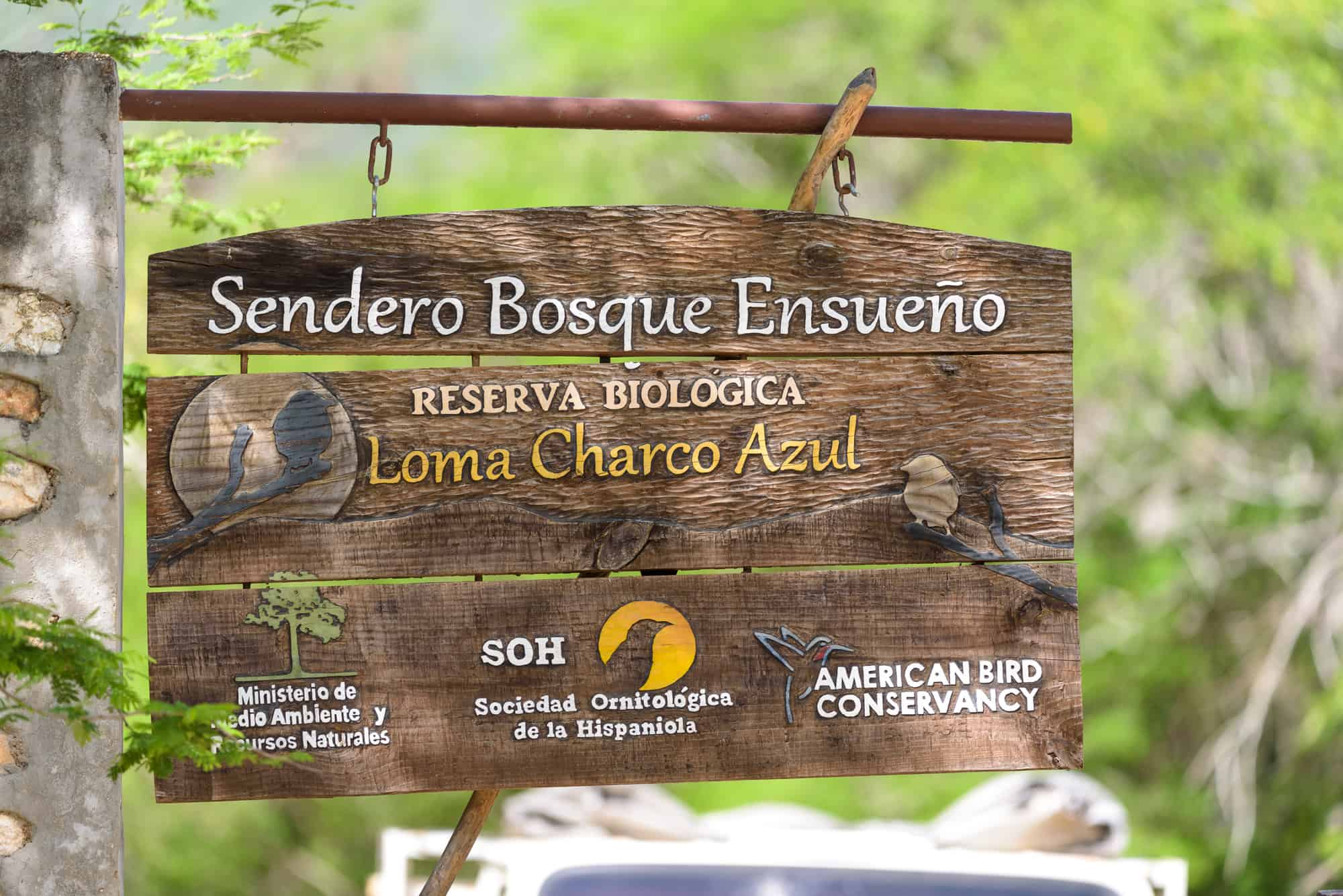 Entrada al sendero de la reserva biológica Loma Charco Azul donde se advierte el apoyo de diversas instituciones y ONG´s.