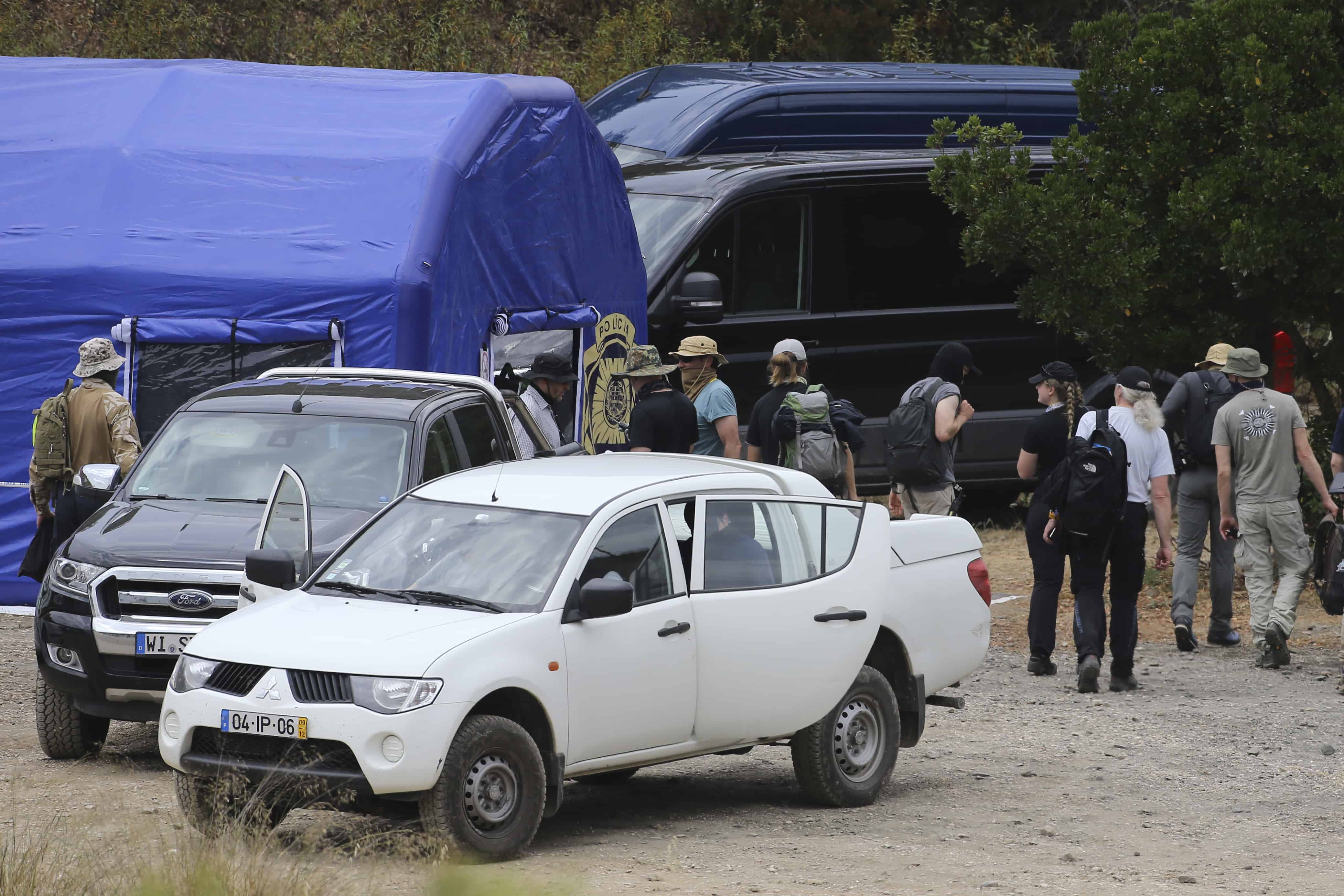 Los equipos de búsqueda de la policía regresan a una carpa de operaciones desde vehículos registrados en Alemania y Portugal cerca de Barragem do Arade, Portugal, el martes 23 de mayo de 2023.