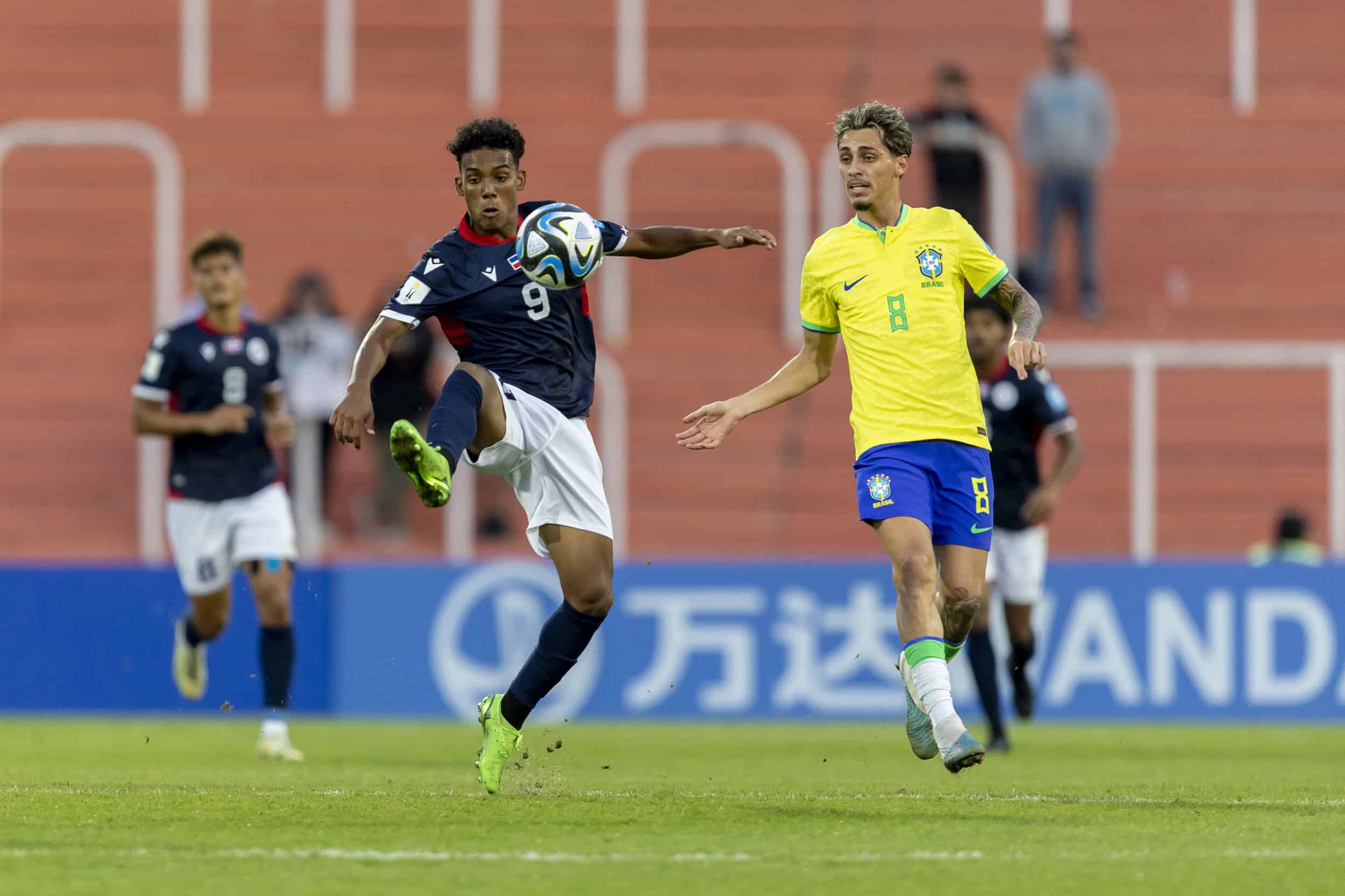Anyelo Gómez intenta controlar un balón ante la presencia de un defensor brasileño.
