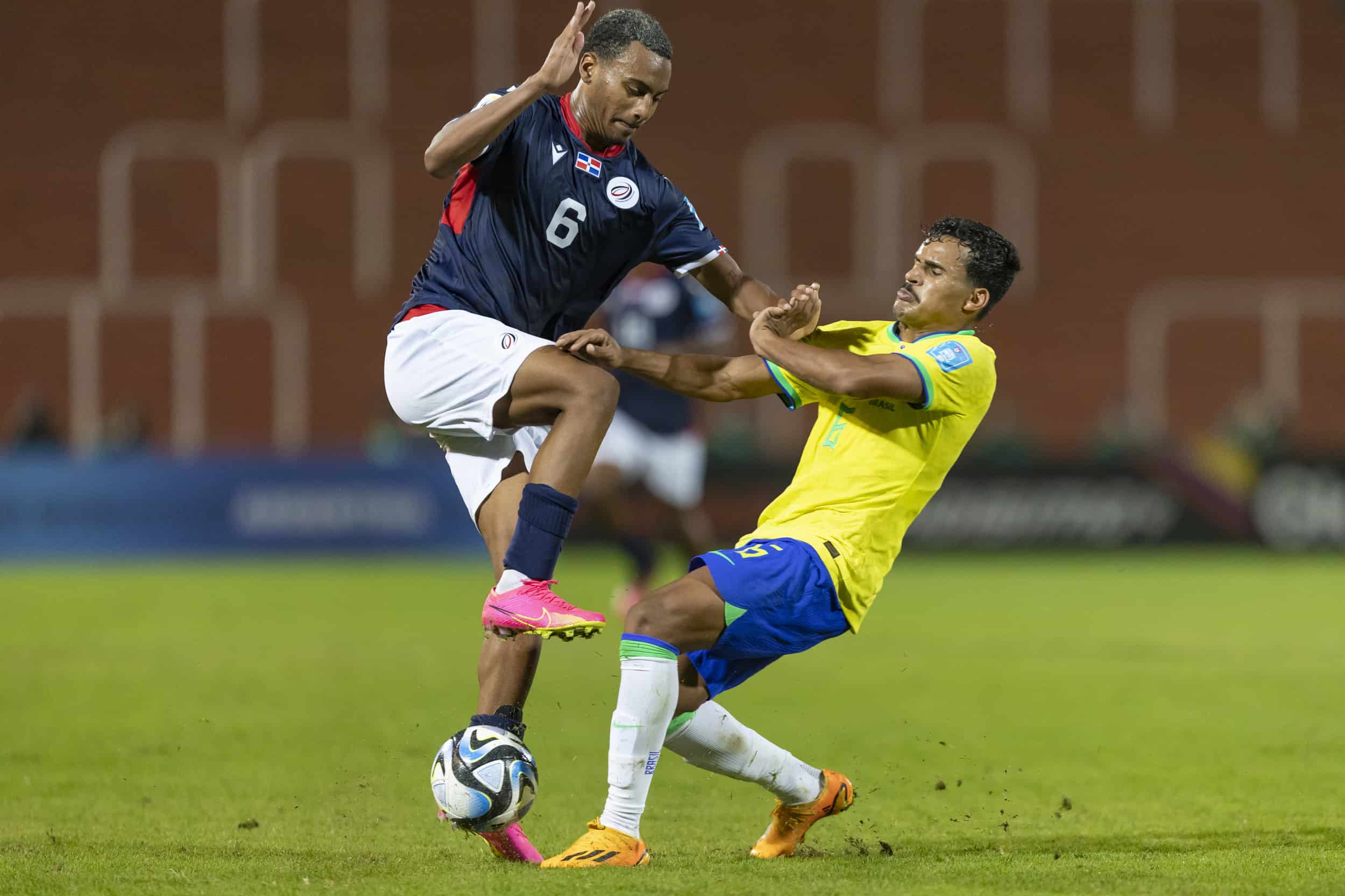 Israel Boatwright choca contra un defensor brasileño durante el segundo tiempo del encuentro que Brasil ganó por goleada (6-0) a República Dominicana.