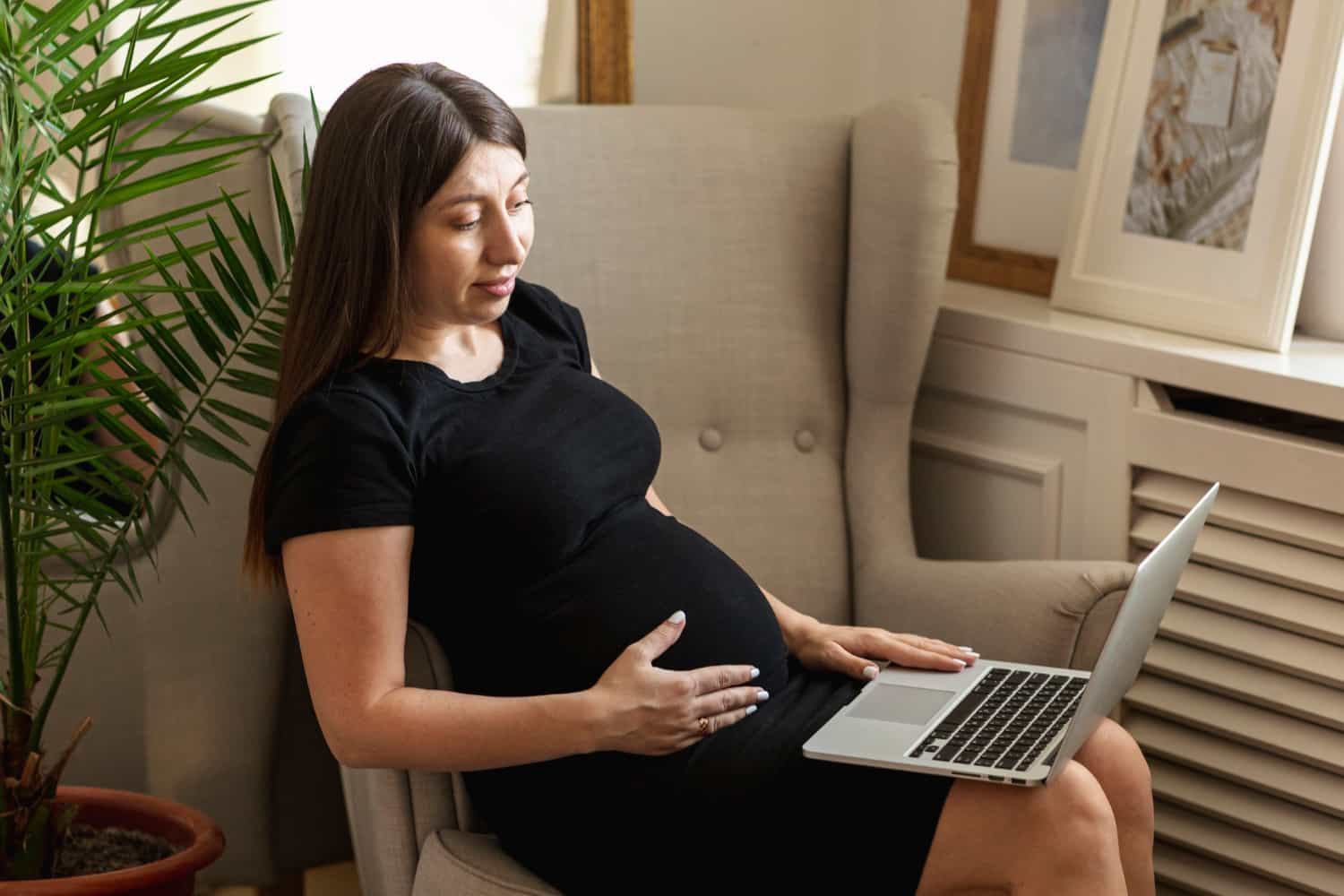 tiro-medio-mujer-embarazada-sosteniendo-su-laptop-4de5734a.jpg