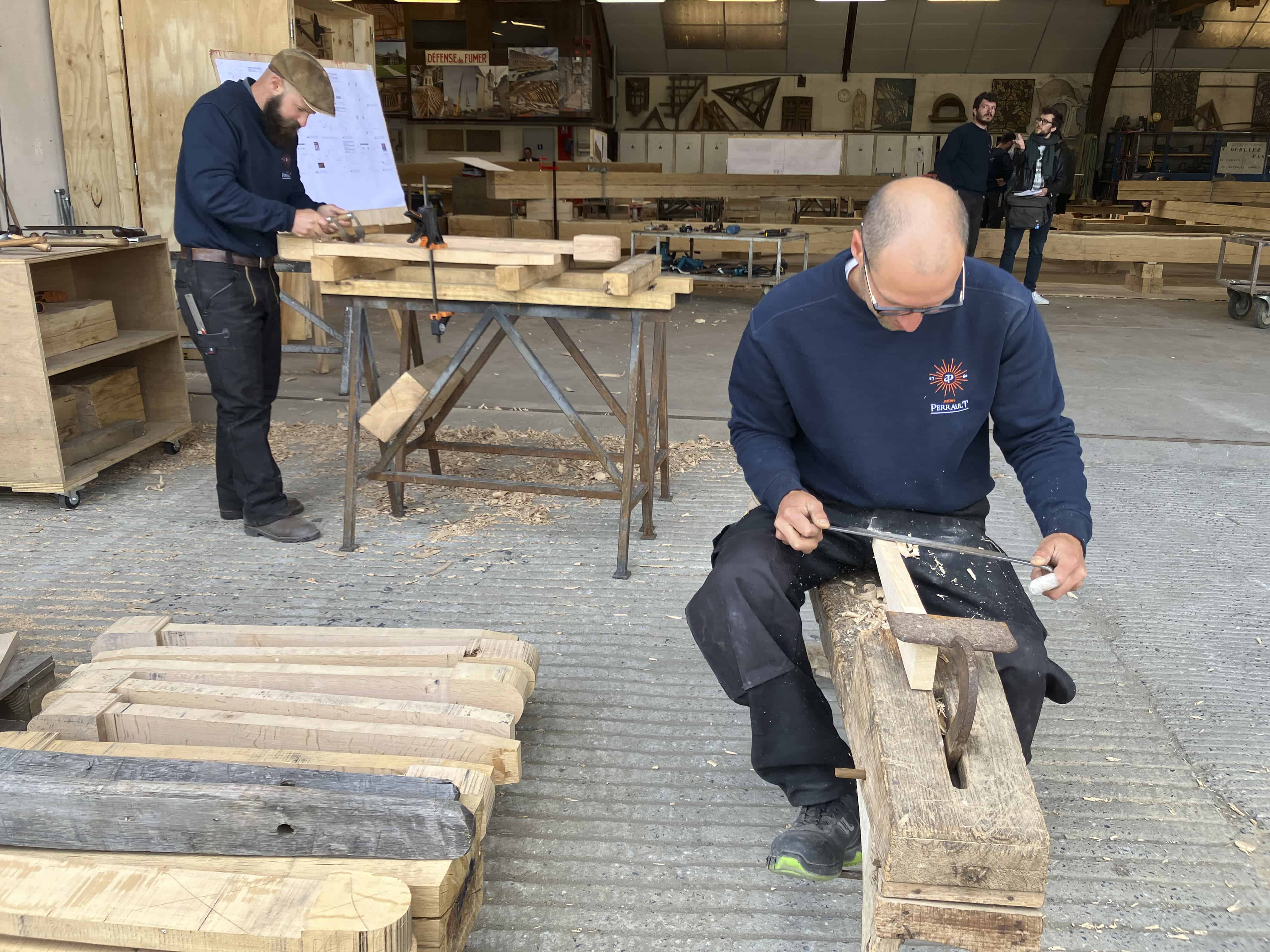 Carpinteros trabajan en piezas que formarán parte de la estructura del nuevo tejado de la catedral de Notre Dame de París, el 25 de mayo de 2023, cerca de Angers, en el oeste de Francia.