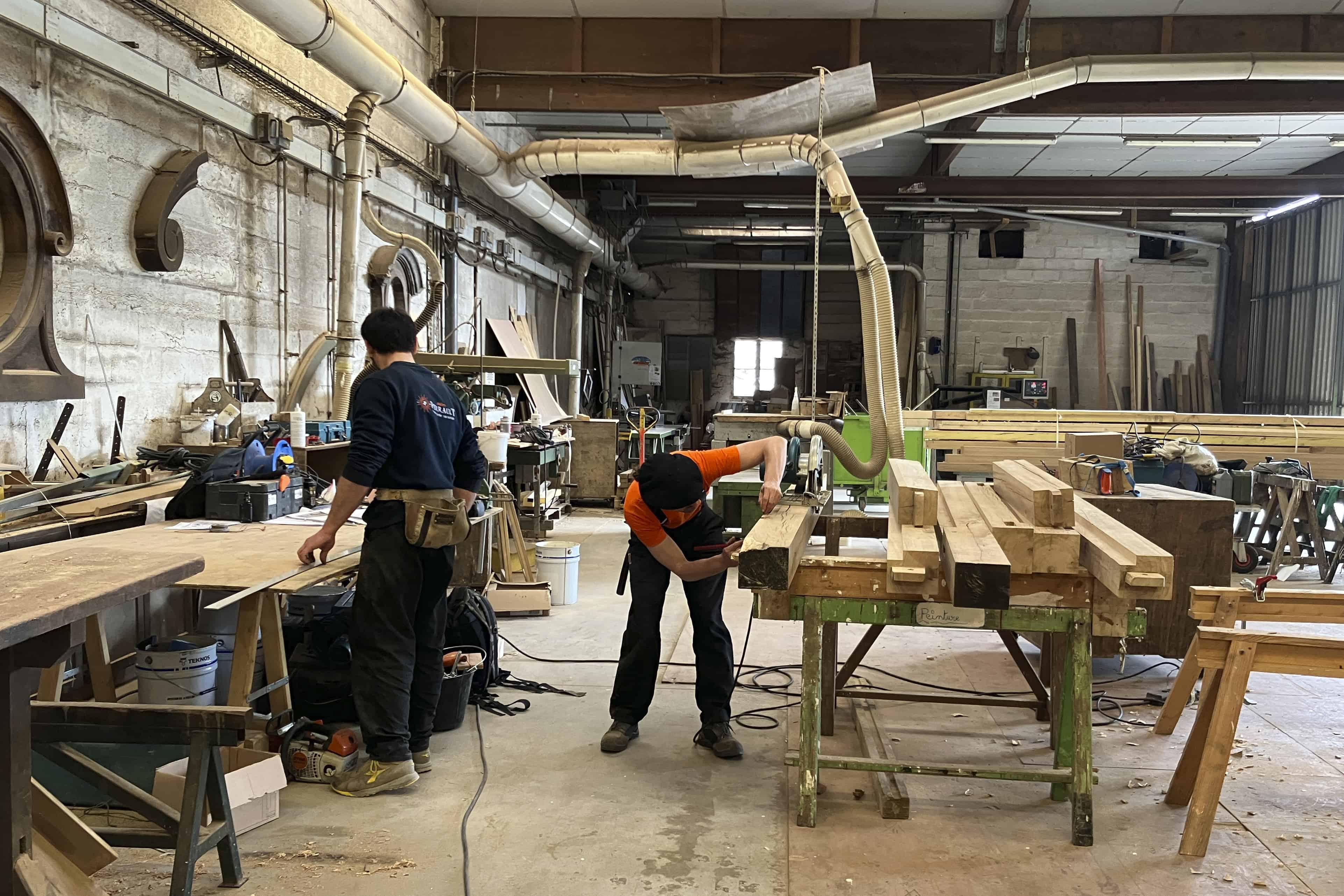 Carpinteros trabajan en piezas de madera que formarán parte de la estructura del nuevo tejado de la catedral de Notre Dame de París, el 25 de mayo de 2023, cerca de Angers, en el oeste de Francia.