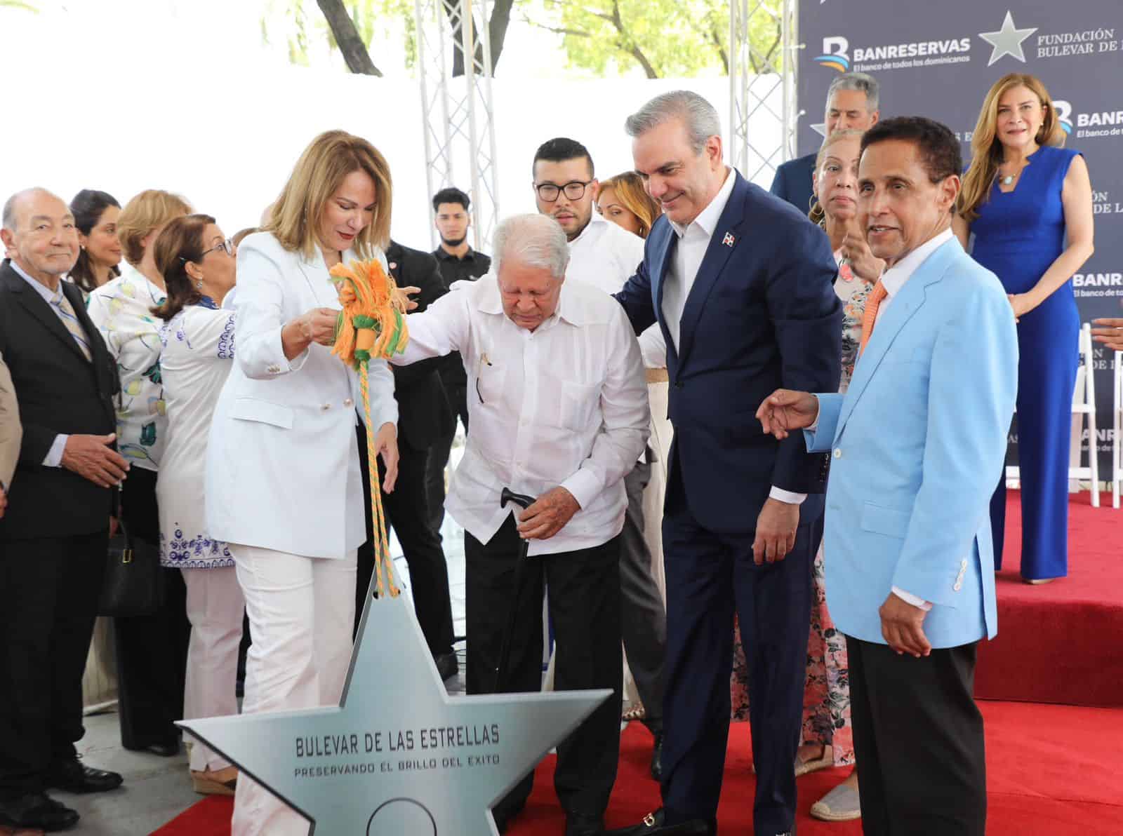 El presidente Luis Abinader en el reconocimiento al arista Fernando Casado. Le acompañan la ministra de cultura, Milagros Germán y el periodista Carlos Batista Matos, presidente de la Fundación Bulevar de las Estrellas.