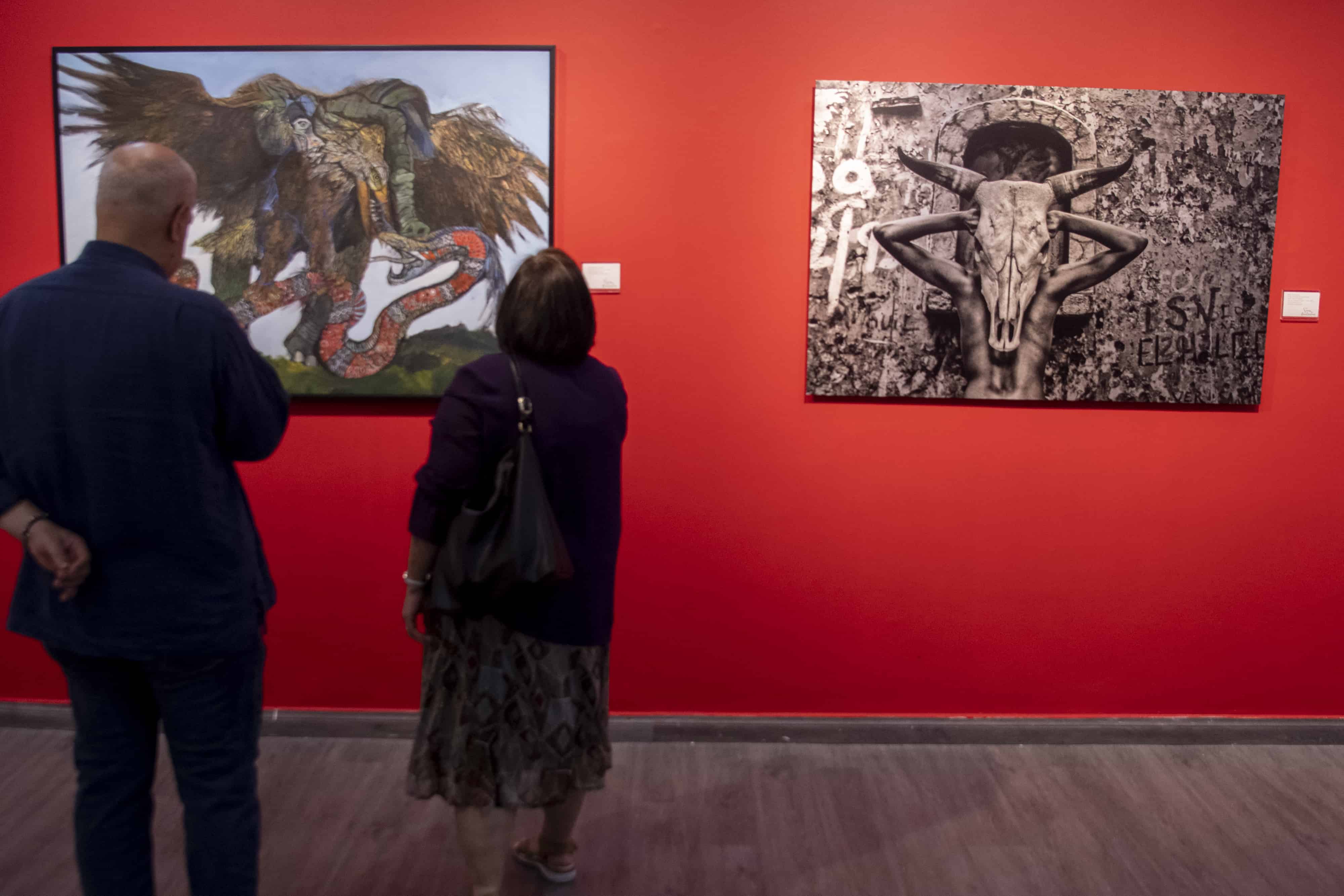 Expectadores aprecian las obras Aguidermo y su presa (Omar Molina) y El rostro de la identidad (Kelvin Naar).