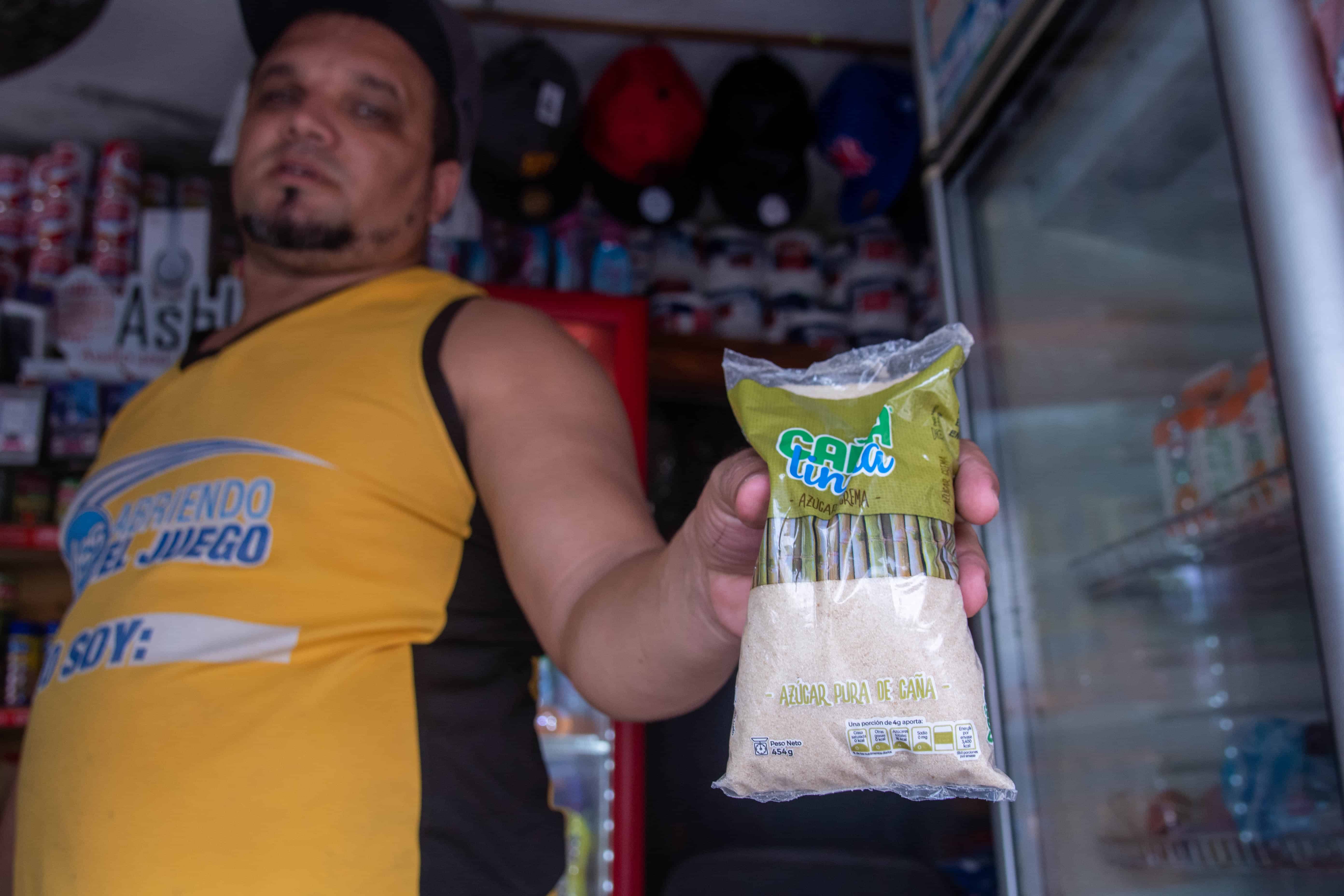 Osmíres Suárez, propietario del Mercadito Popular, ubicado en la calle Eterna, muestra un saco de una libra de Caña Linda, la marca que vende en el local. Fue de los que reportó mantener la azúcar crema al mismo precio de siempre, a 24 pesos el paquete.