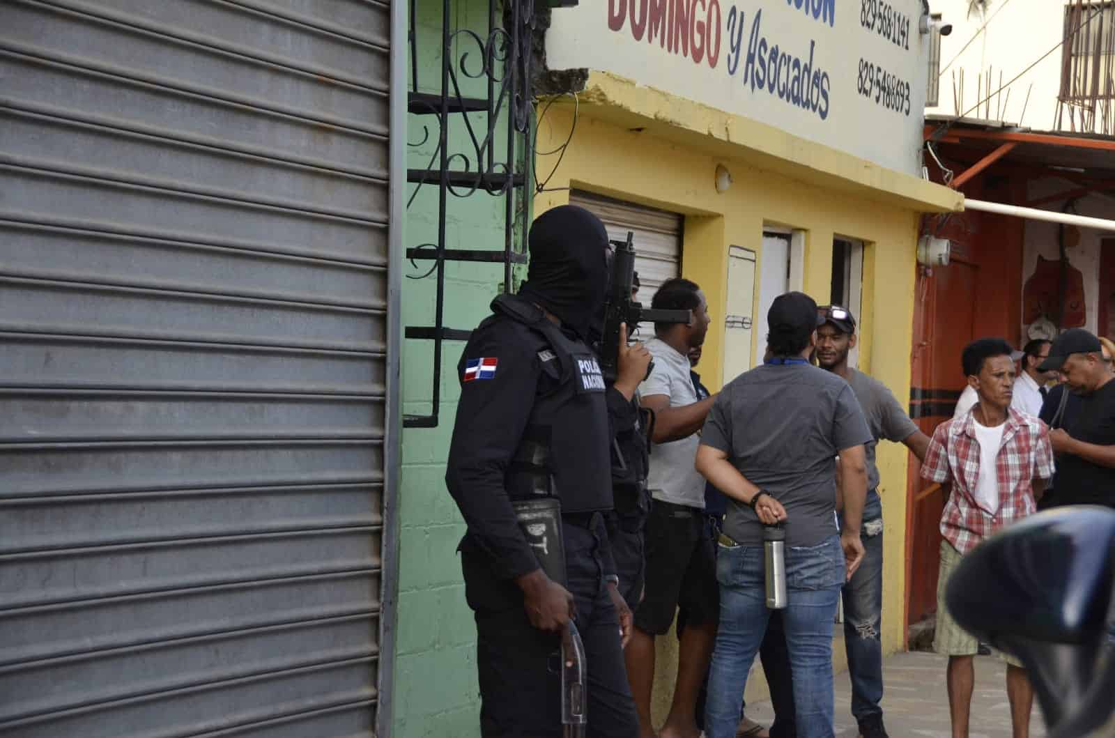 Agentes de la Policía Nacional detienen personas durante los allanamientos de la  Operación Halcón IV en Santiago.