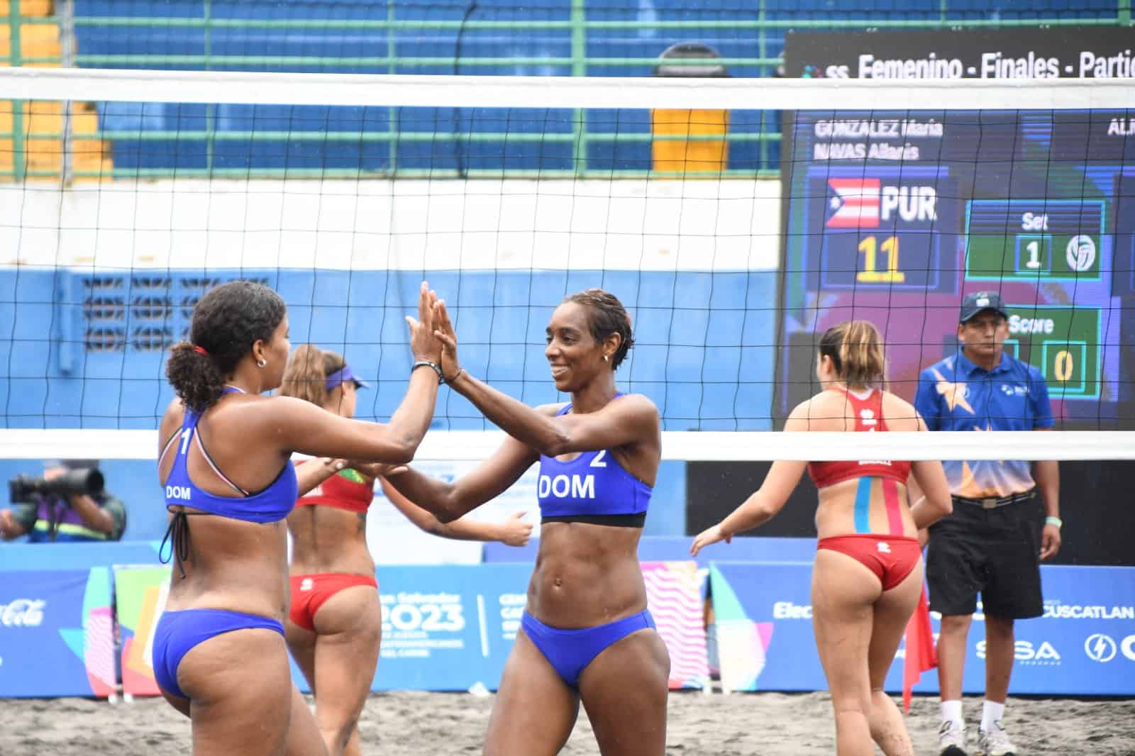 Julibeth Payano, izq. y Bethania Almánar, de República Dominicana, se felicitan durante el partido por el oro del torneo de voleibol de los Juegos Centroamericanos y del Caribe San Salvador 2023 contra Puerto Rico.