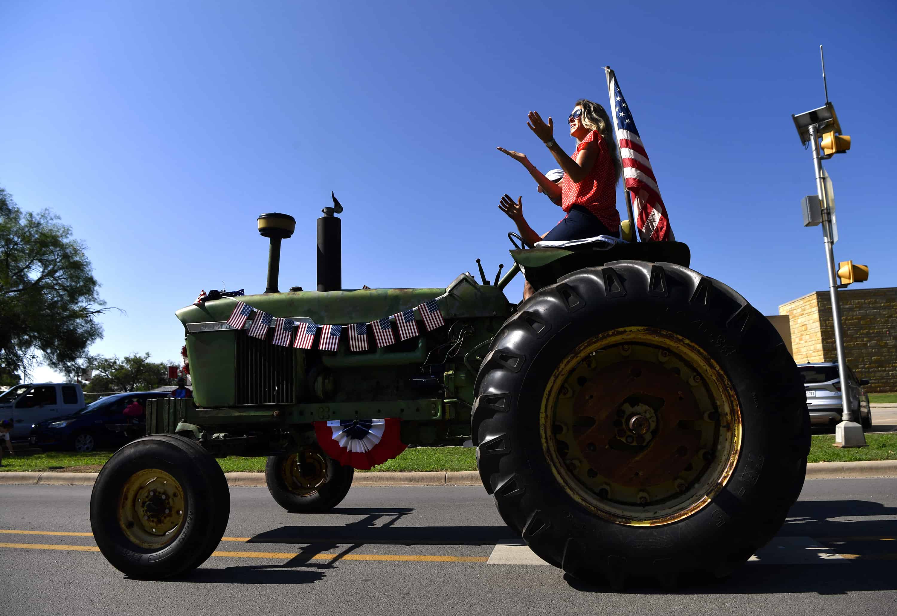 Natalie Christopherson y Ben Gates viajan en un tractor John Deere 4020 de 1967 durante el desfile del Día de la Independencia del martes en Buffalo Gap, Texas, el martes 4 de julio de 2023.