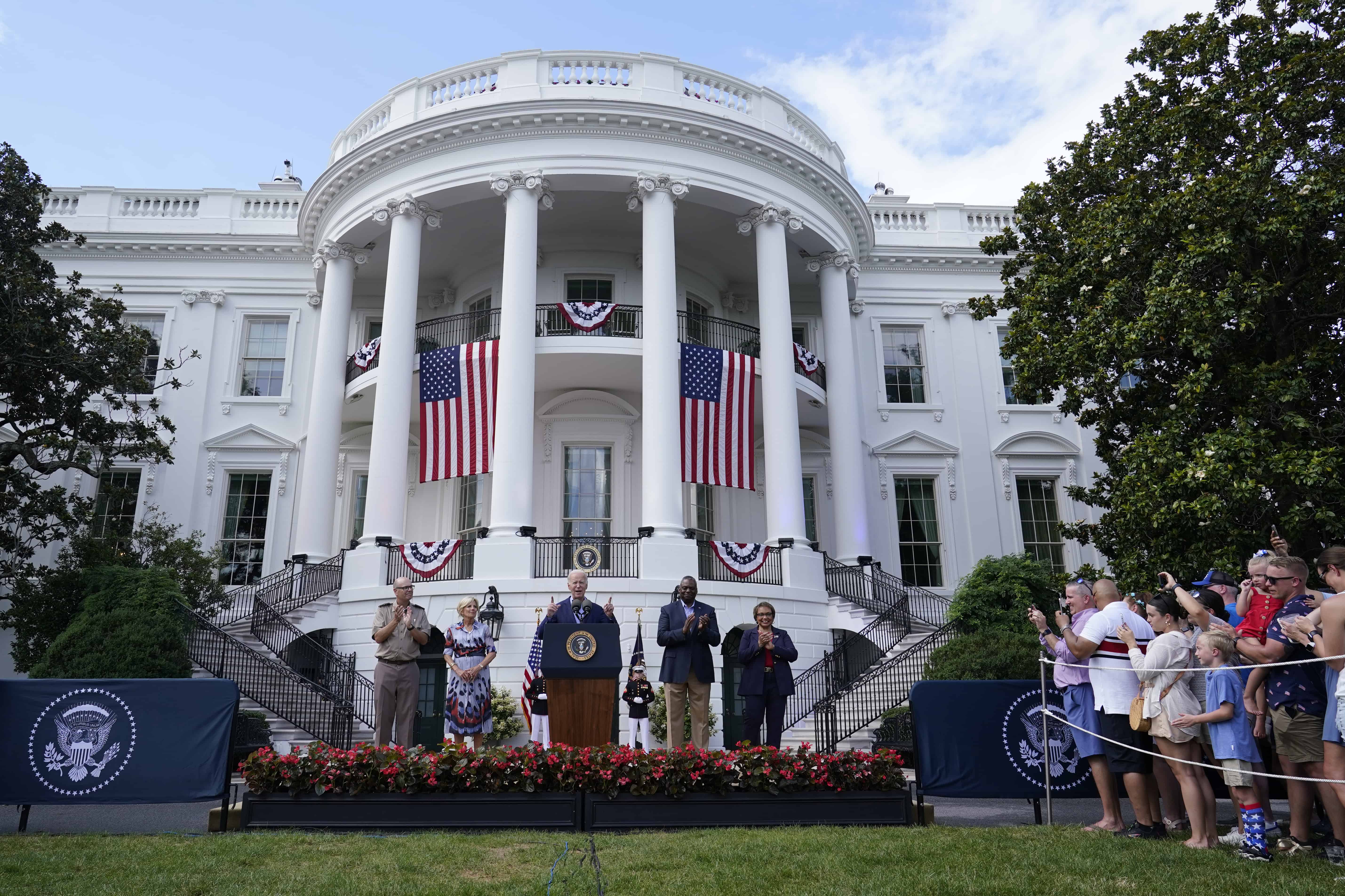 El presidente Joe Biden, en el centro, de pie con, desde la derecha, el capellán superior de la Oficina Militar de la Casa Blanca, el coronel del ejército John Barkemeyer, la primera dama Jill Biden, el secretario de Defensa Lloyd Austin y su esposa Charlene Austin, hablan en el jardín sur de la Casa Blanca en Washington , martes, 4 de julio de 2023, durante una barbacoa con familias de militares en servicio activo para celebrar el 4 de julio.