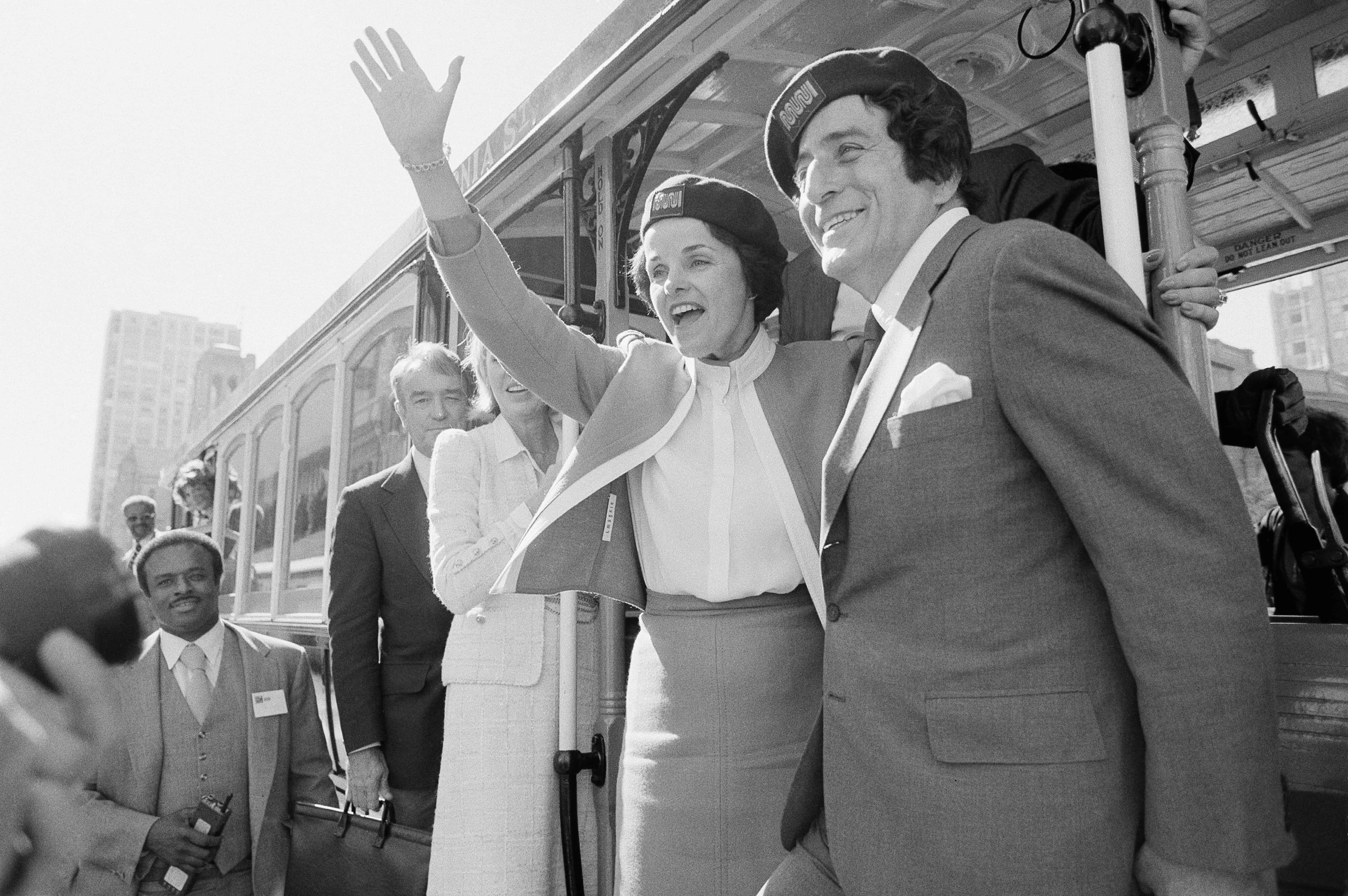 FILE - San Francisco Mayor Dianne Feinstein and singer Tony Bennett, who sang  I Left My Heart in San Francisco, hangs on to the outside of a cable car in San Francisco before taking a test ride, Wednesday, May 2, 1984.