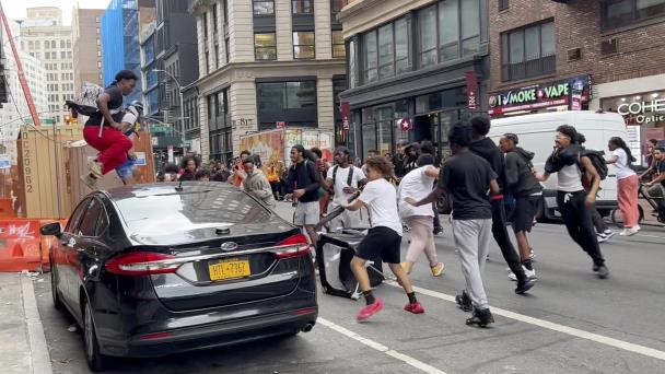 Multitud reunida en Union Square, NY, abruma a policía, salta sobre autos y lanza objetos